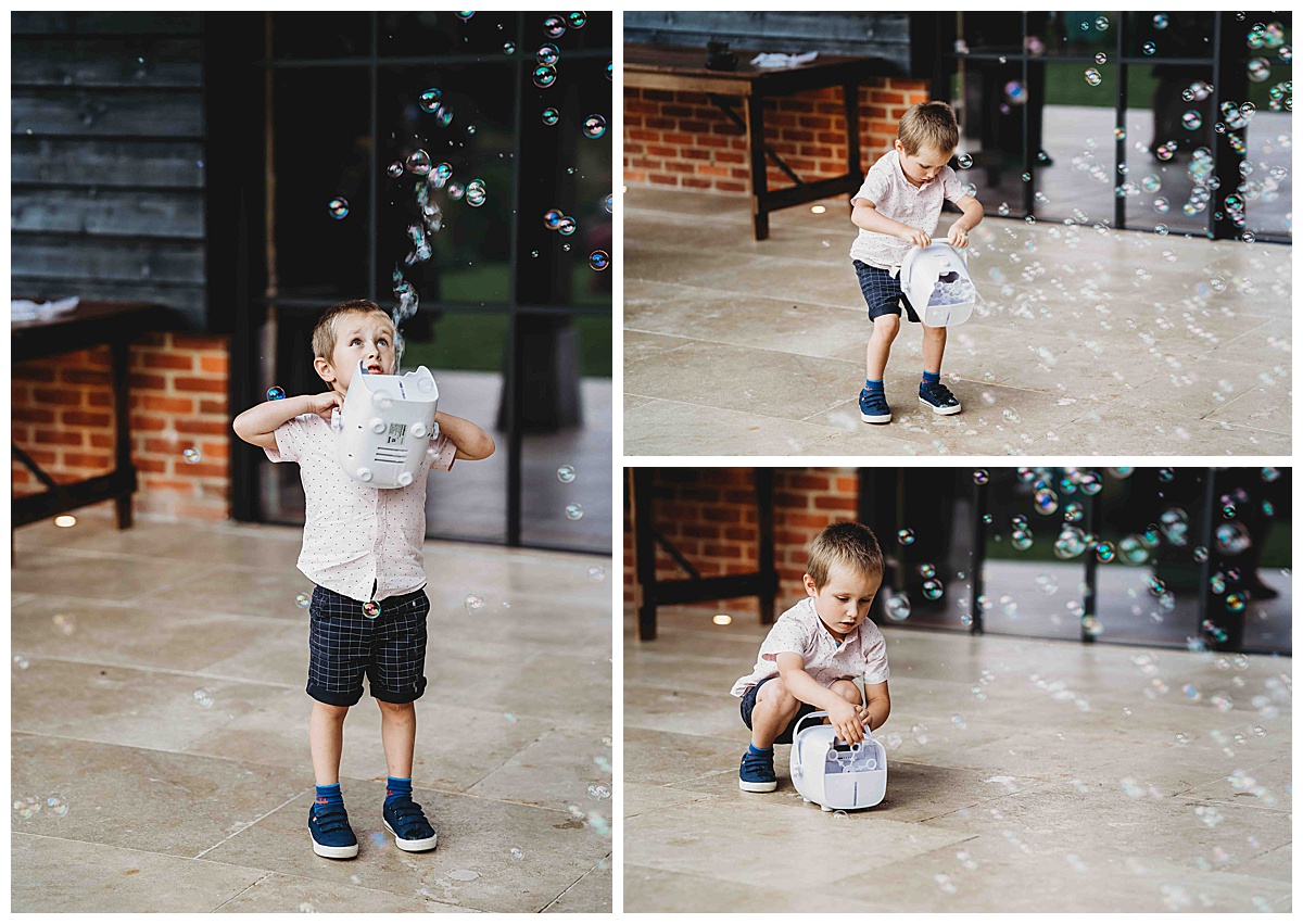 a wedding guest child playing with the bubble machine taken by a post barn photographer