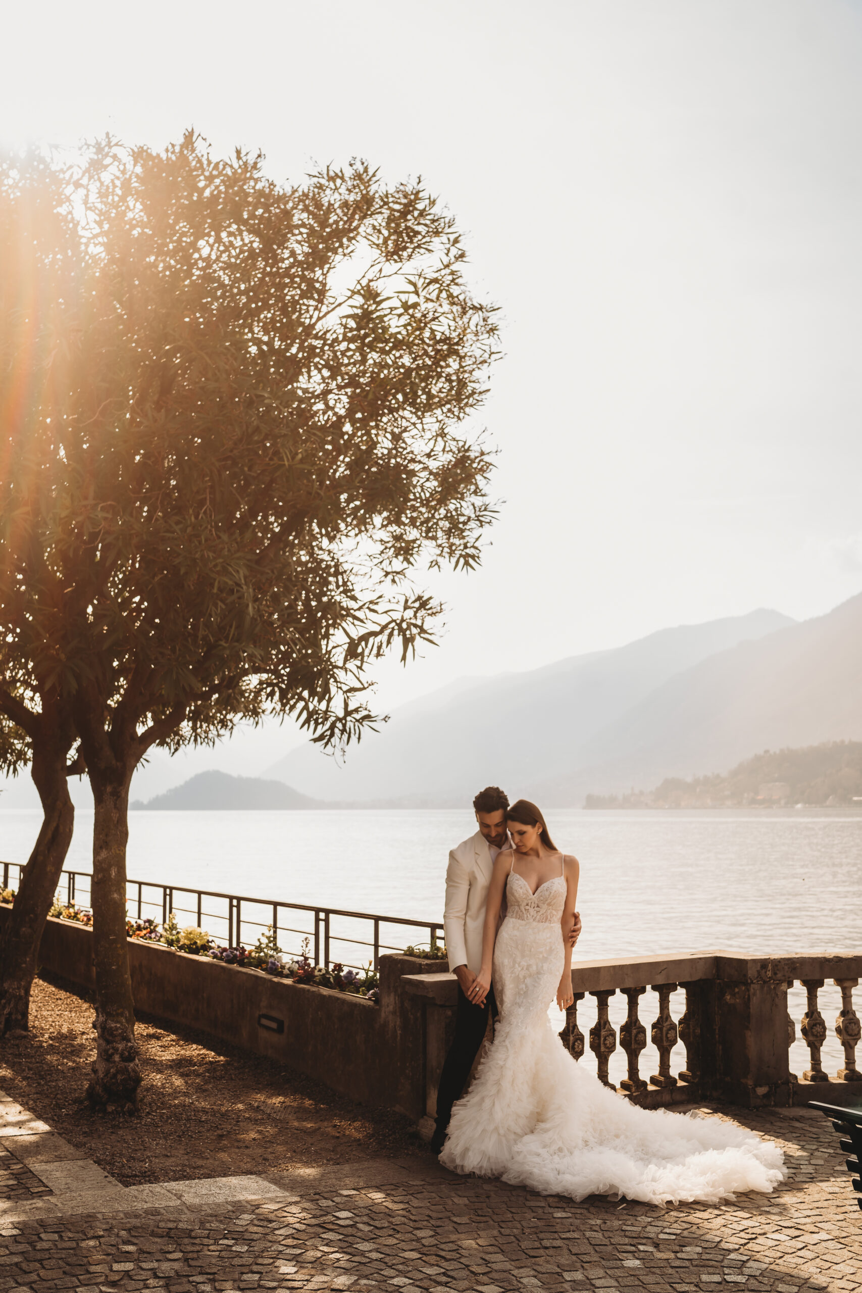 a couple cuddling at sunset in front of Lake como taken by a lake como photographer 