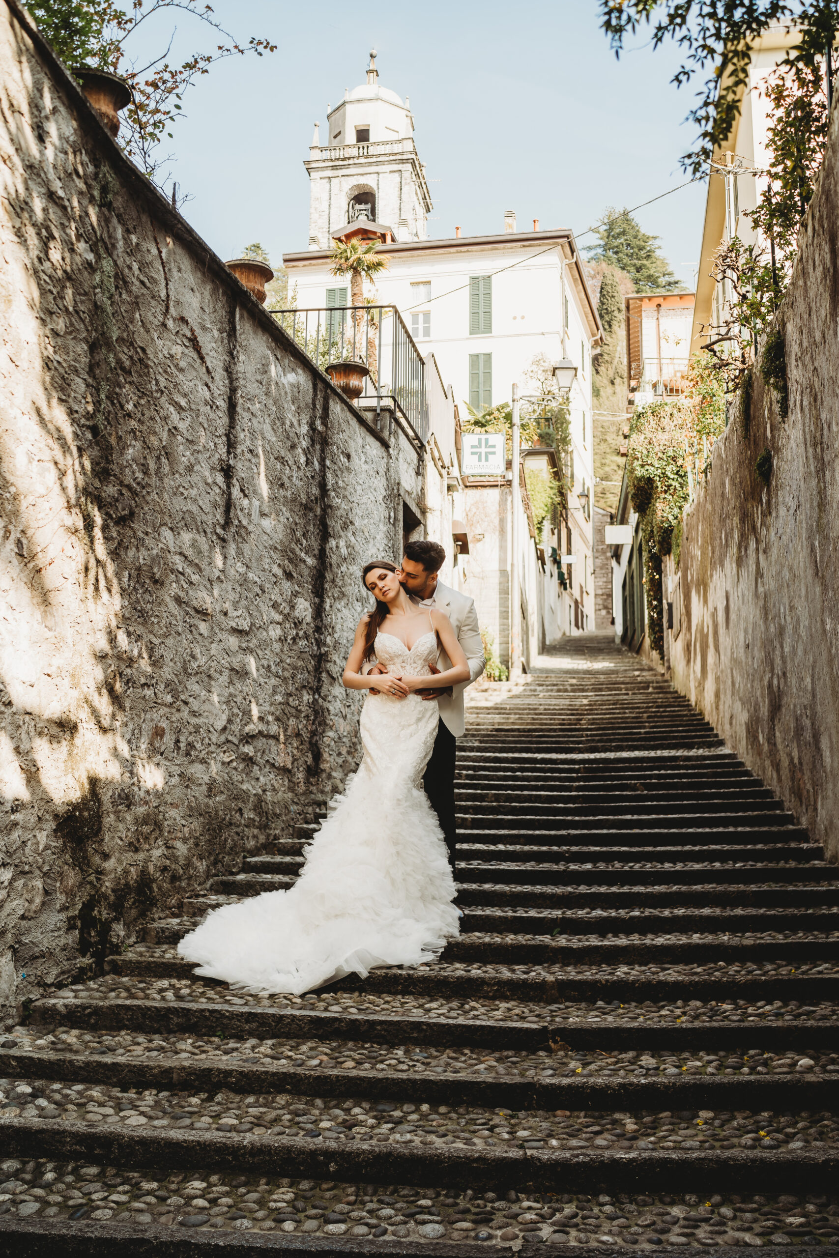 a bride and groom cuddling on the steps of Bellagio after their Lake Como wedding