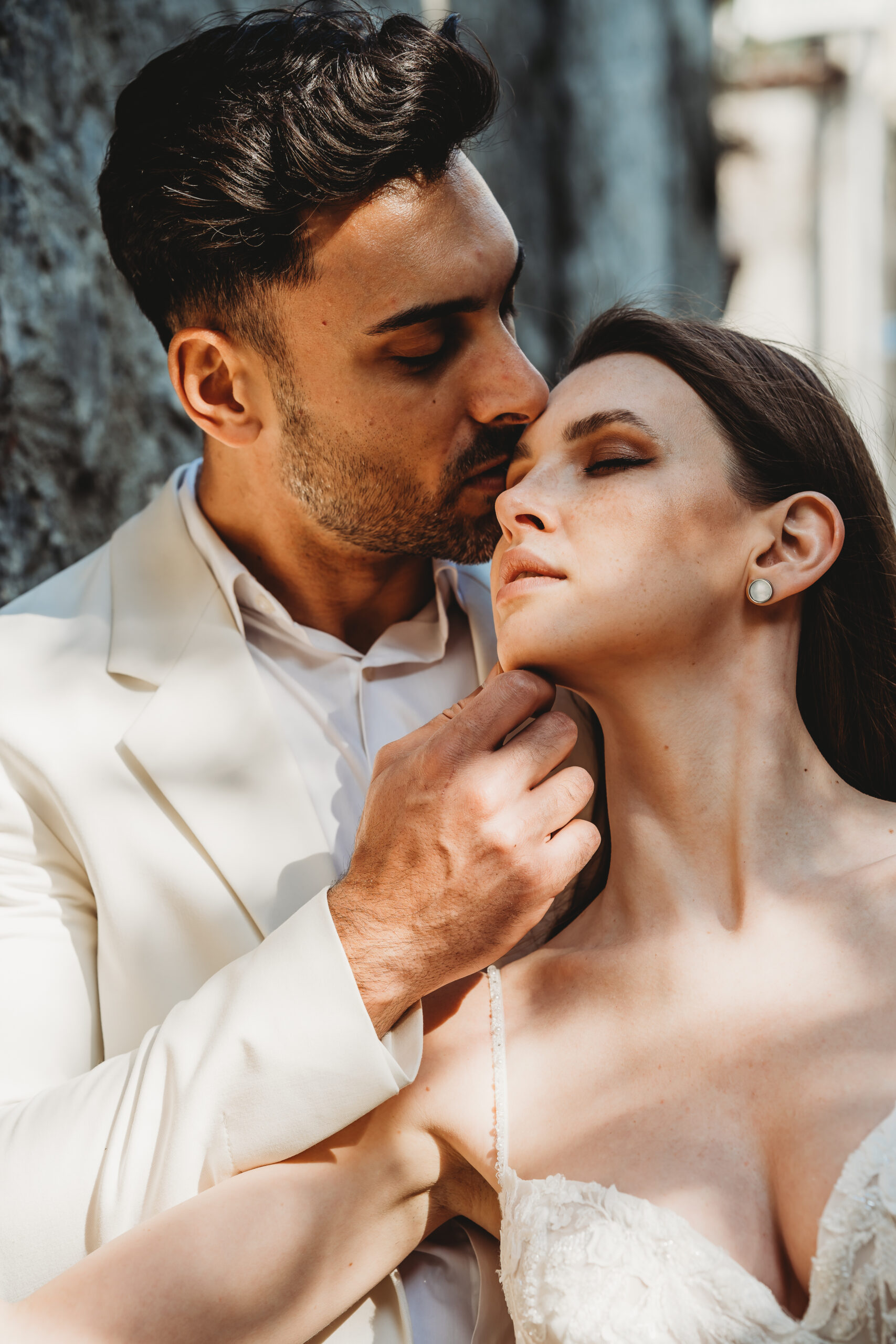 a newly married husband kissing his wife on the forehead after a romantic italian wedding
