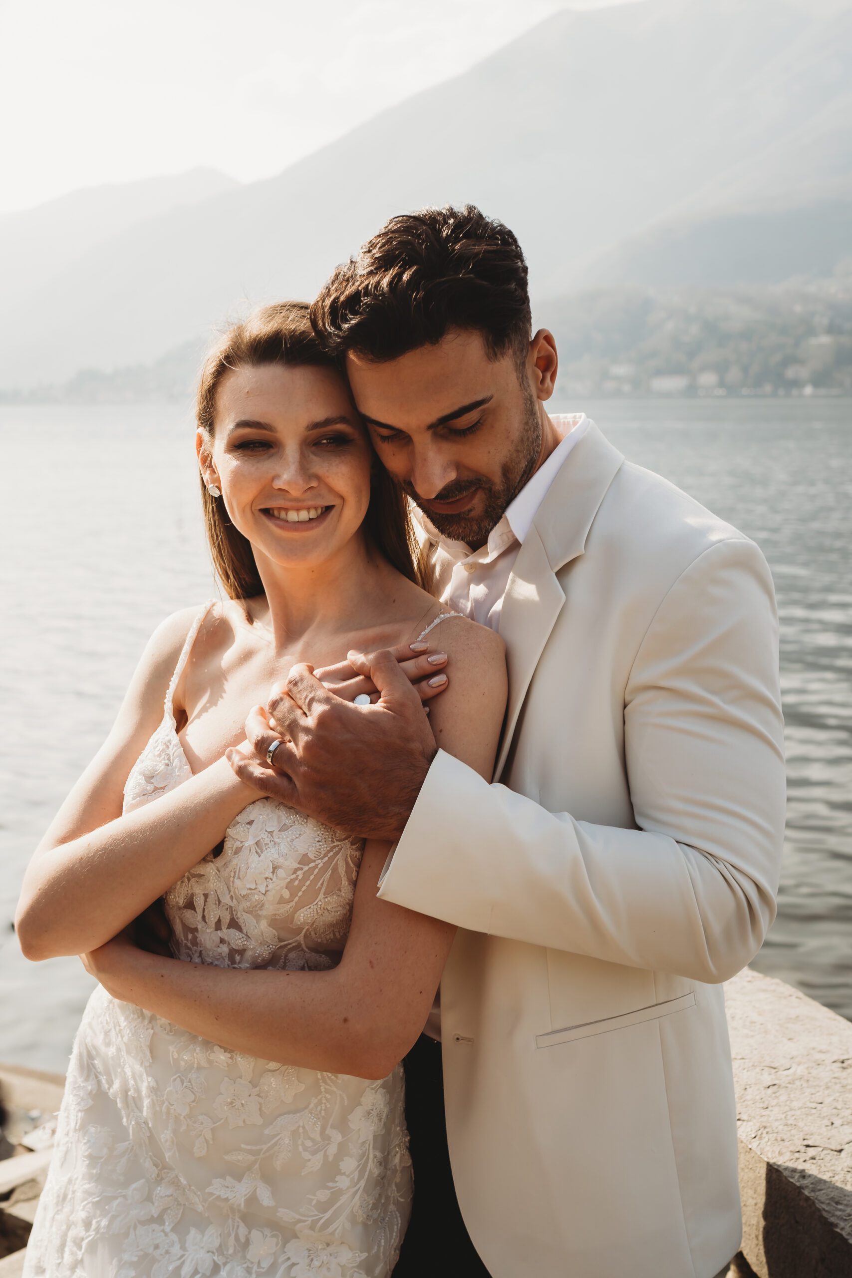 groom cuddles around his new bride after their lake como intimate wedding