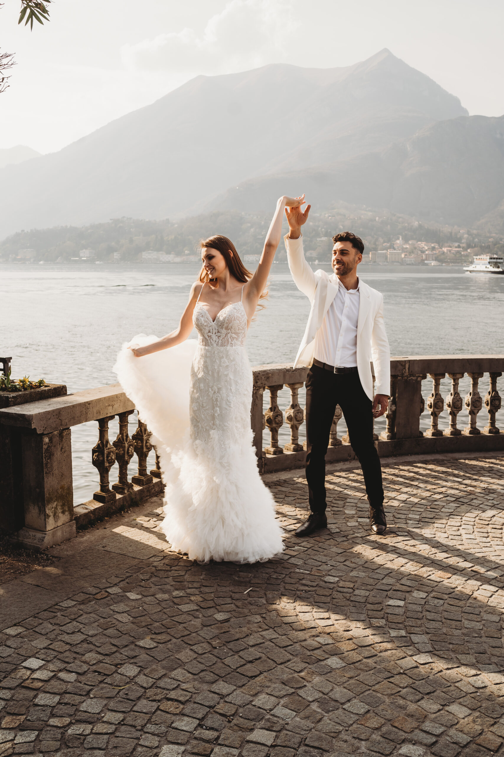 bride and groom dancing in front of the beautiful mountains surrounding lake como