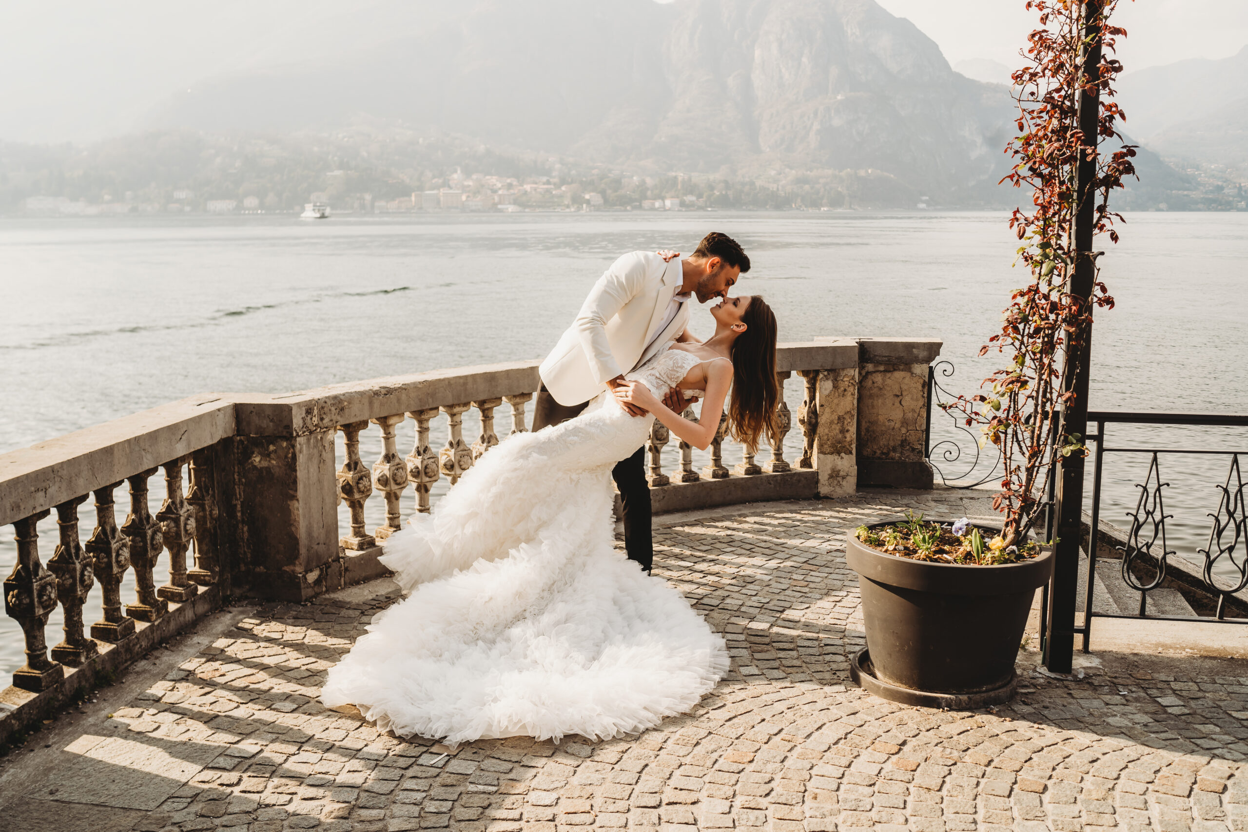 a groom dipping his wife for a kiss at lake como for an italian wedding photographer