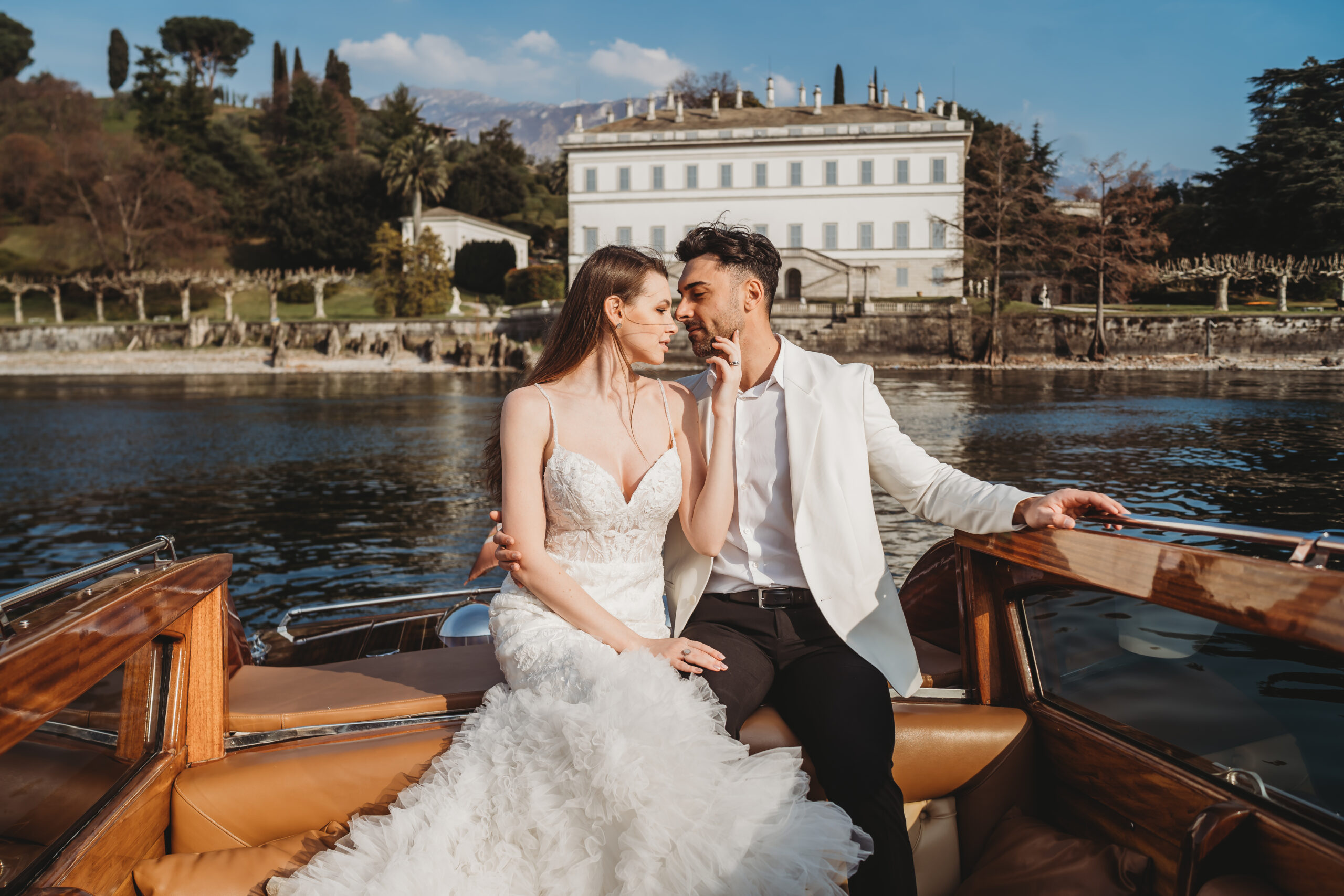 bride and groom on a boat sailing across lake como