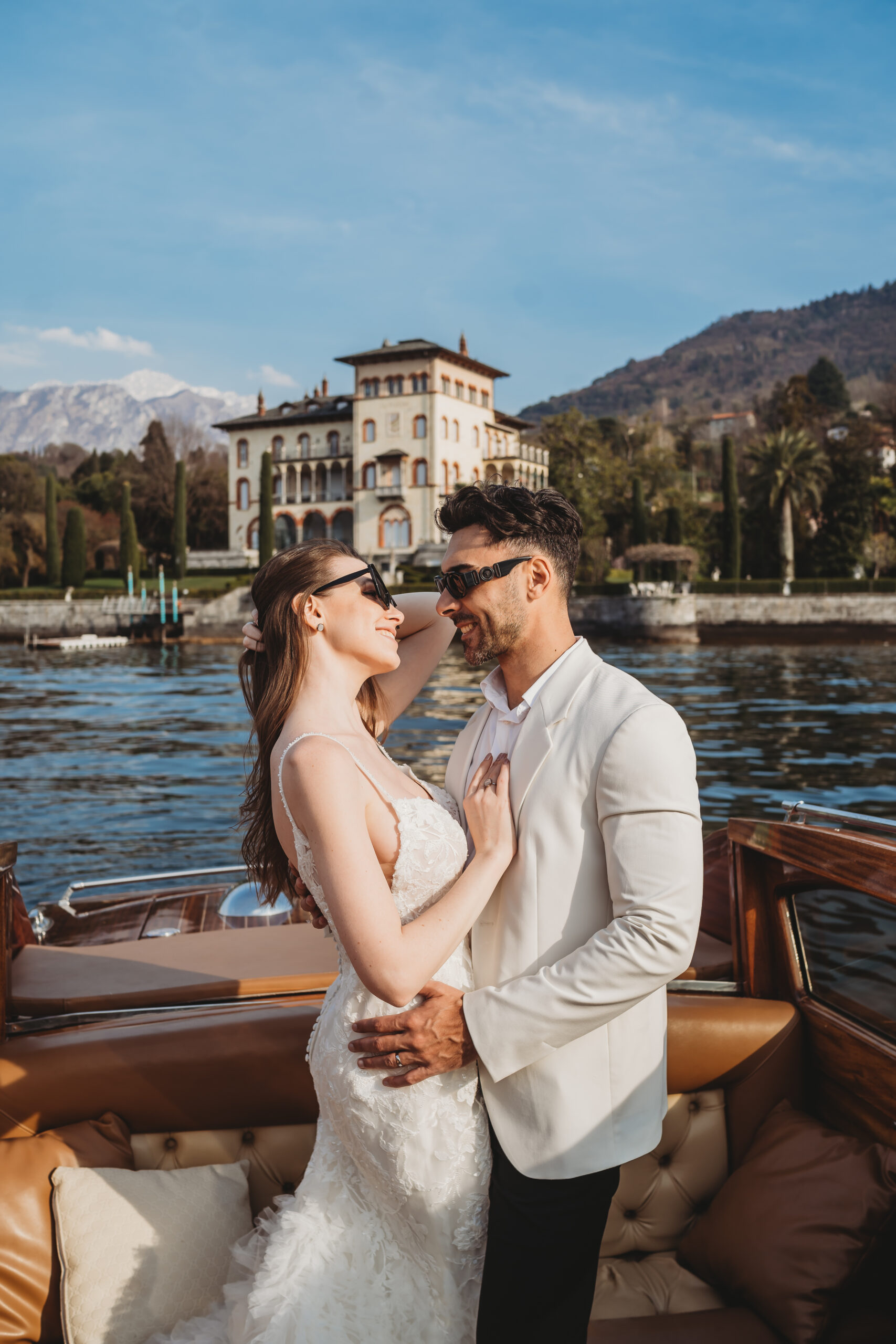 a couple chatting and laughing as they sail across lake como