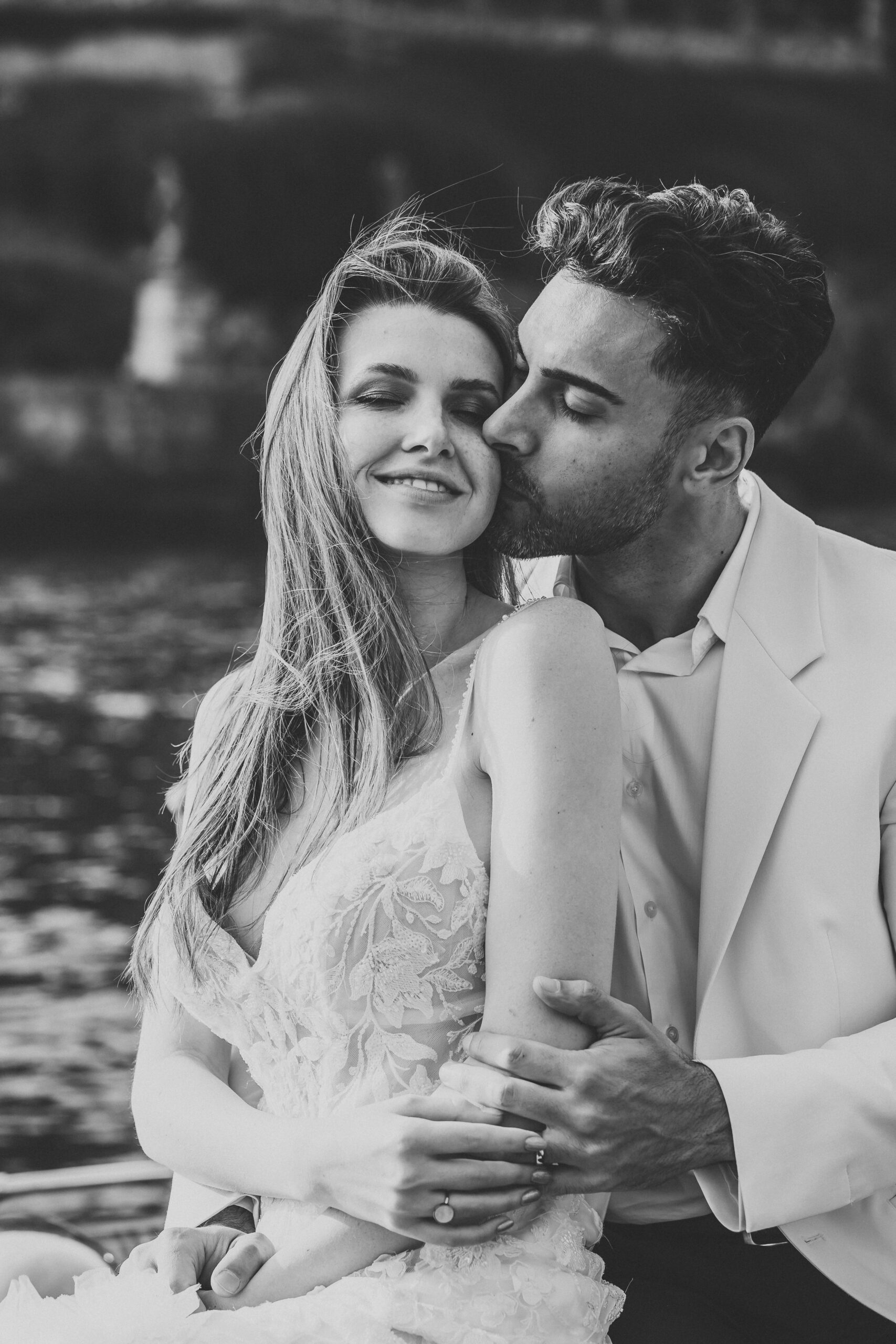 a groom kissing his wife on the cheek as posed by a lake como elopement photographer 