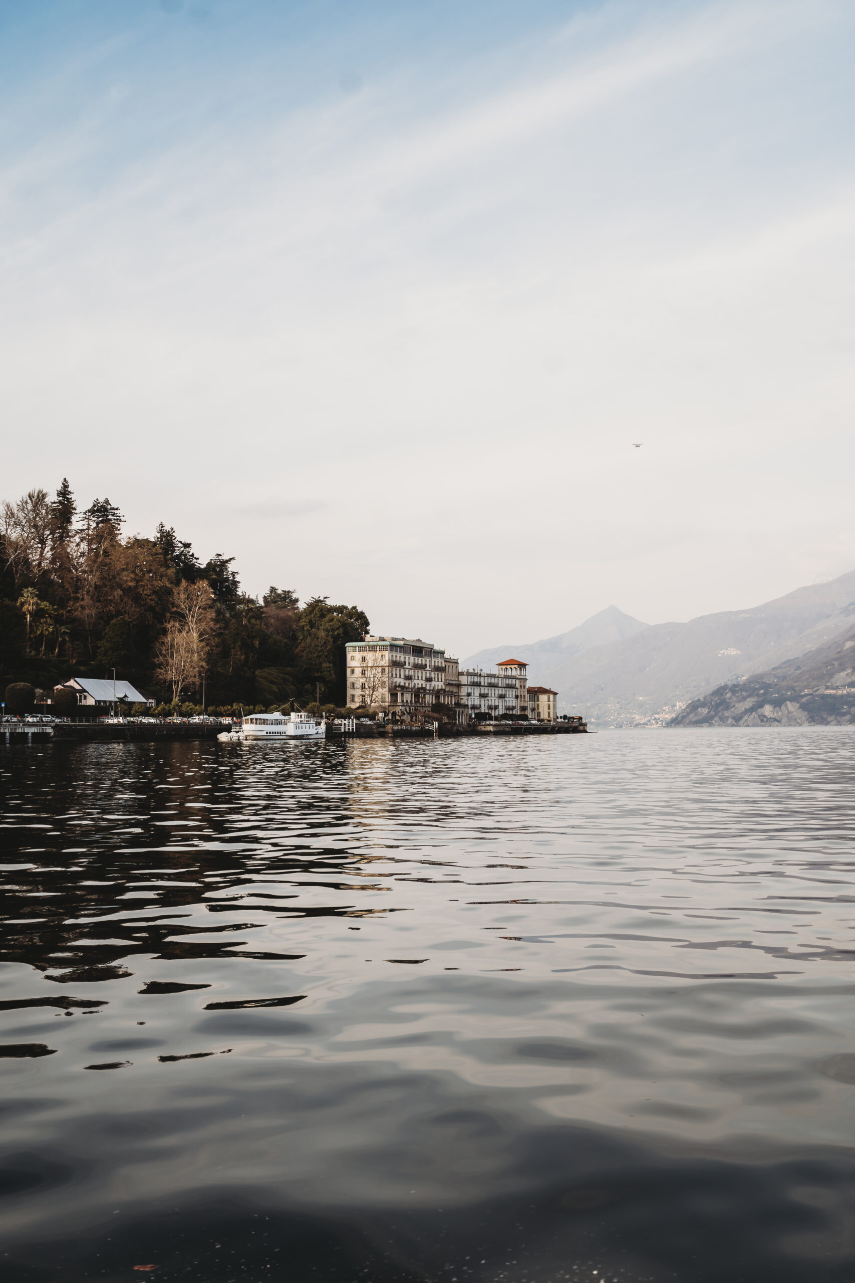 a distant photo of the grand hotel tremezzo on the shores of lake como