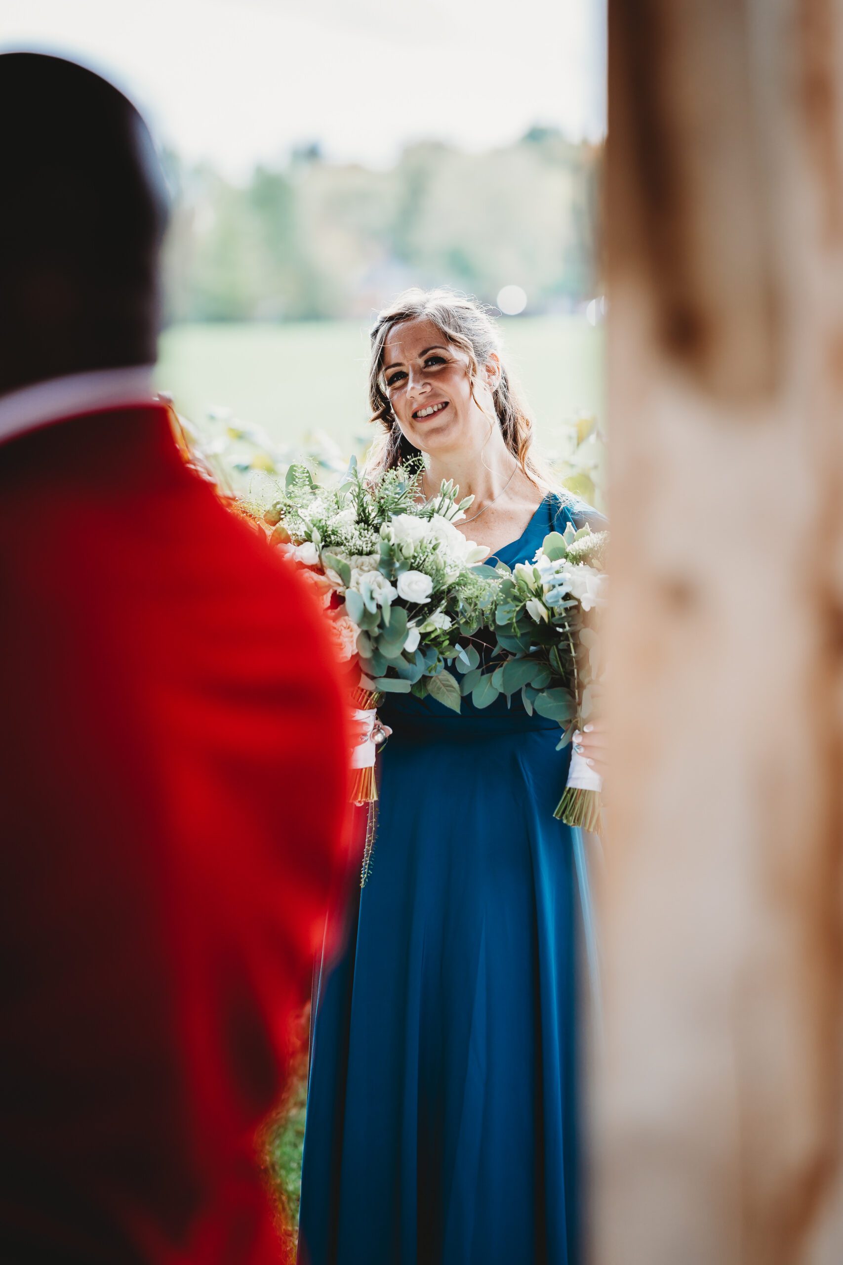 a bridesmaid looking on affectionately as the bride and groom get married