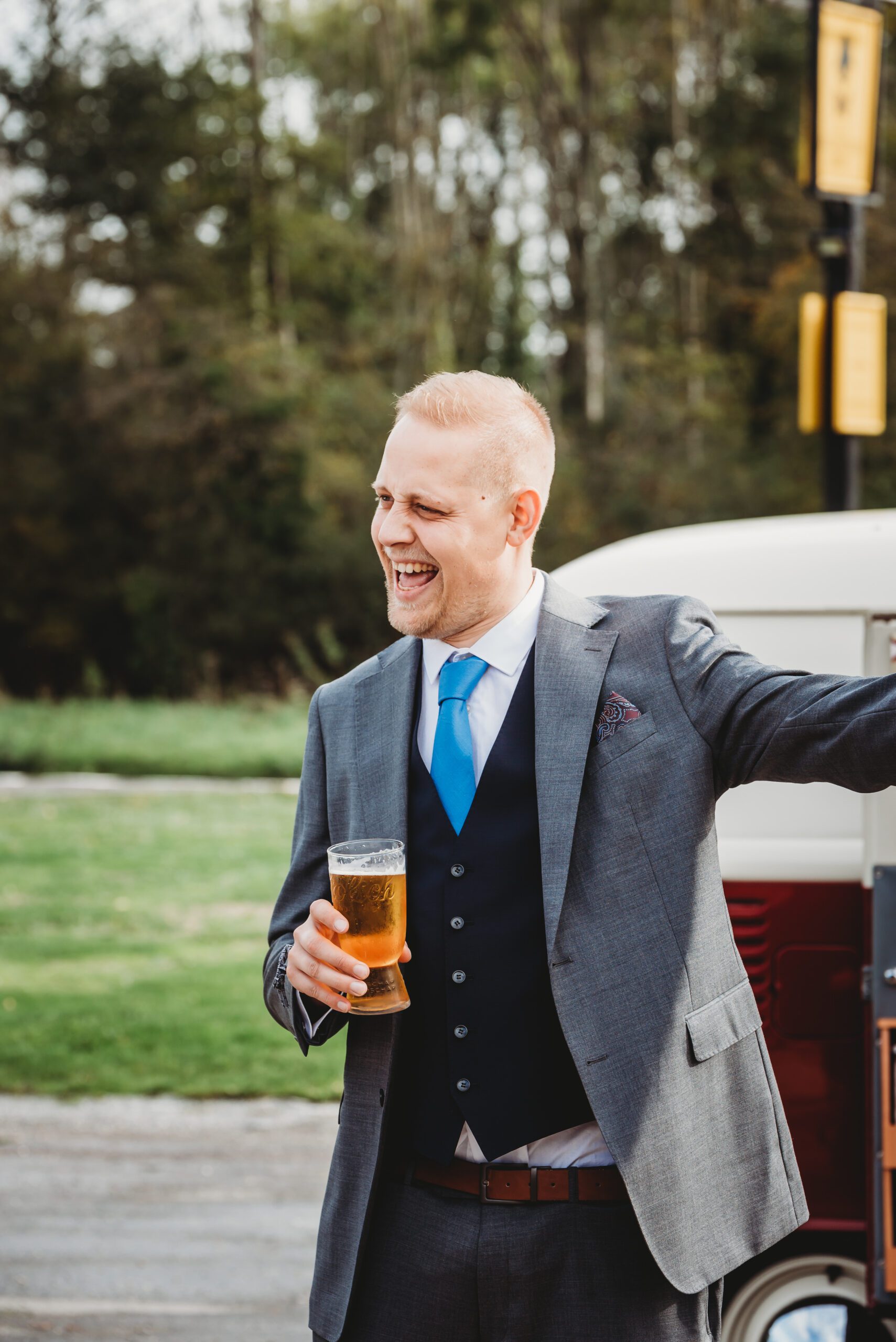 a wedding guest having a laugh with a pint in his hand
