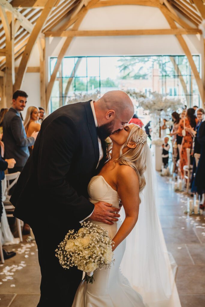 newly weds stopping for a kiss 1/2 way down the aisle 