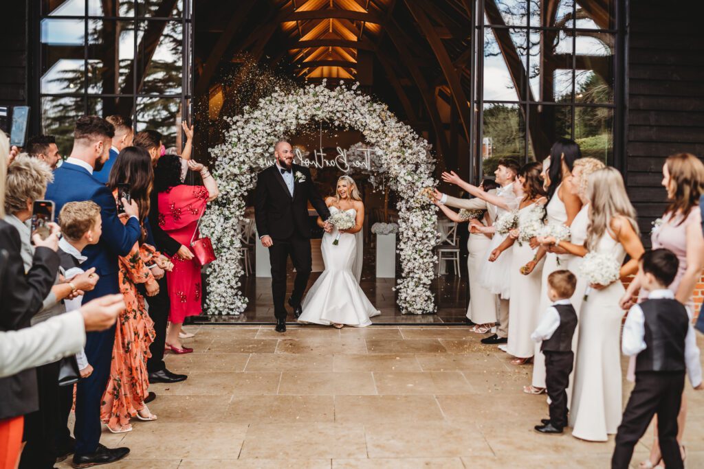 confetti line up throwing rose petals at the couple 