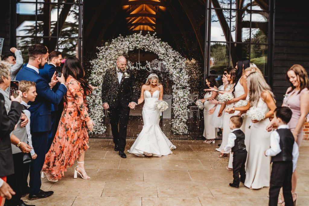 a newbury wedding photographers photo of a couple coming down a confetti line up 