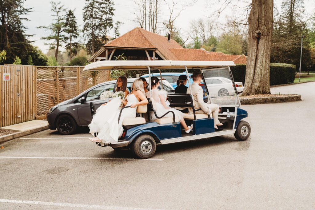 the bridal parting being driven away on a golf cart ahead of the wedding 