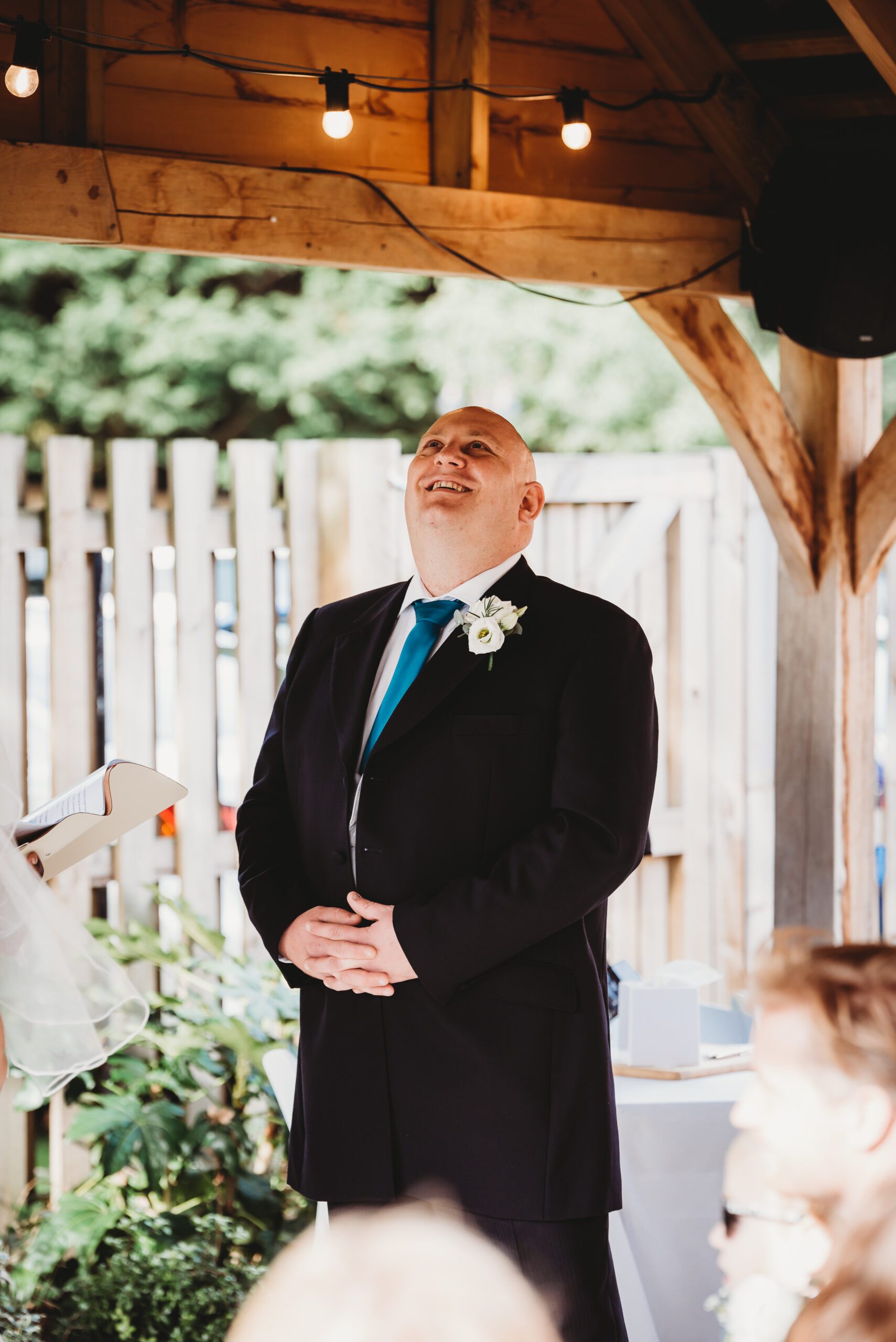 a groom looking up at the air as he gets emotional during her wedding service