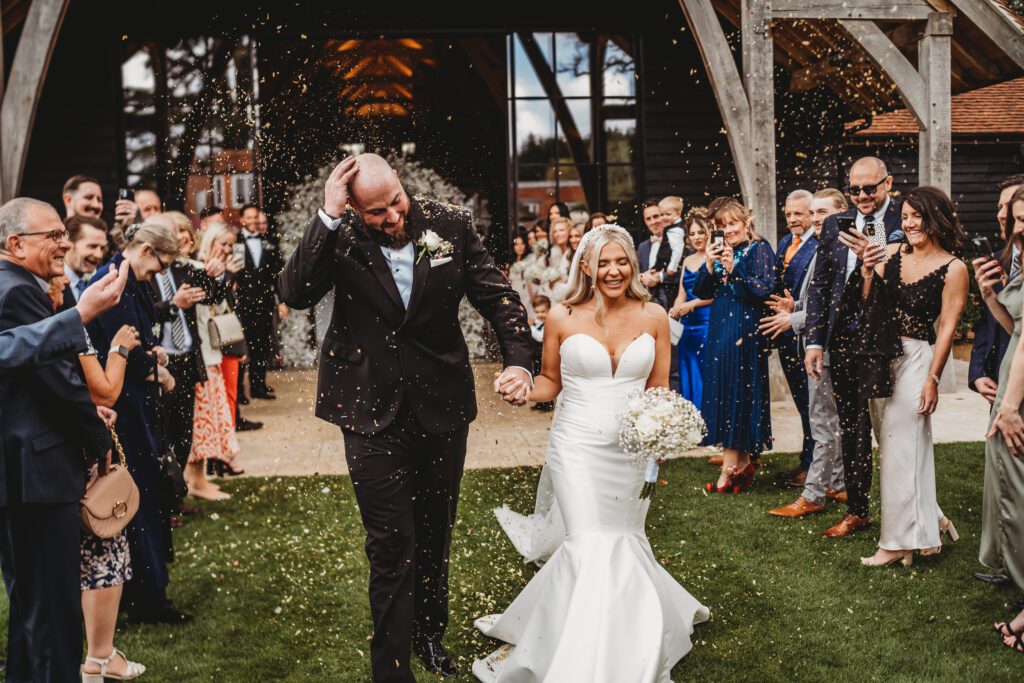 a groom wiping the confetti from his head after their ceremony 