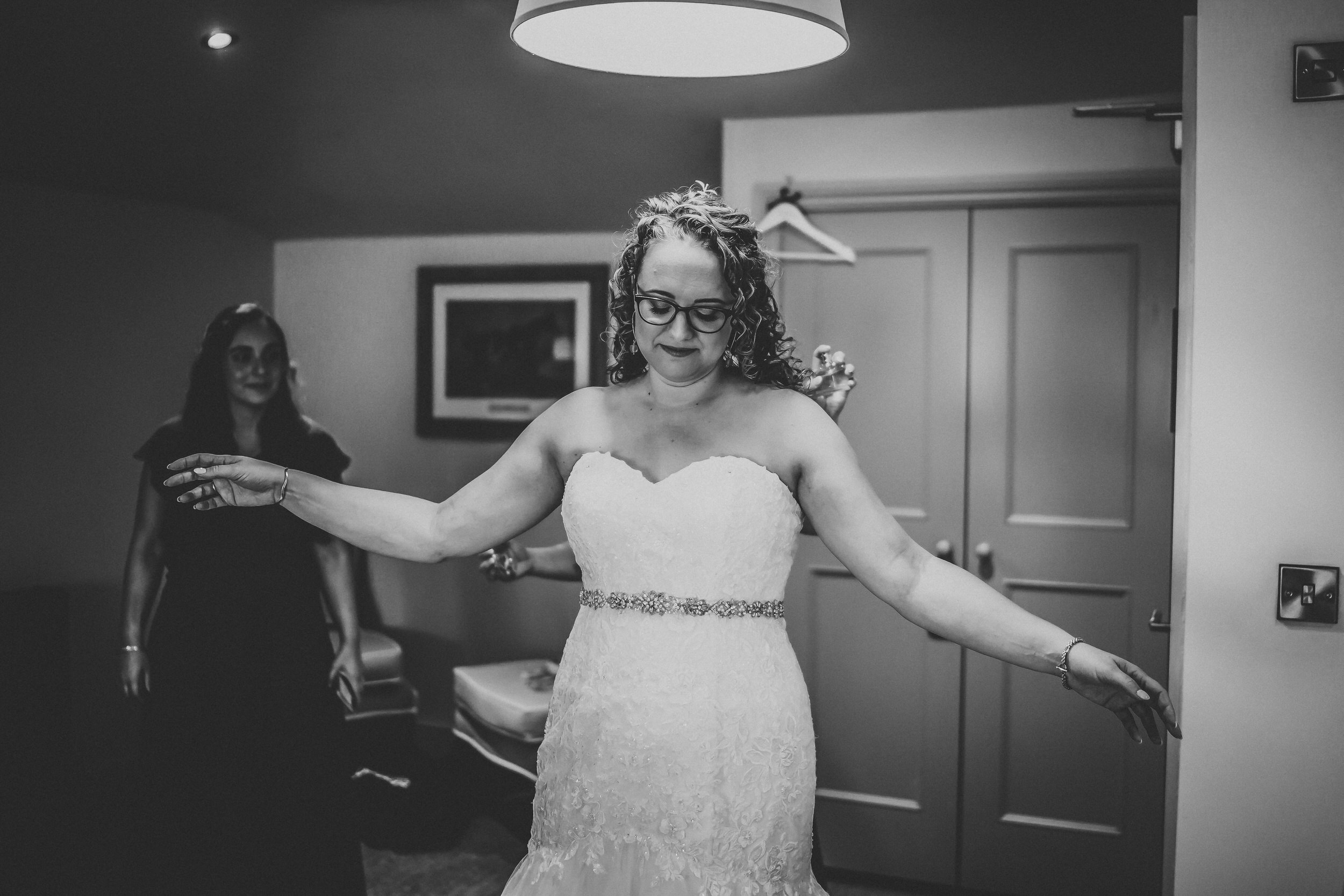 a bride showing how she looks to her bridesmaids before her wedding in hampshire 