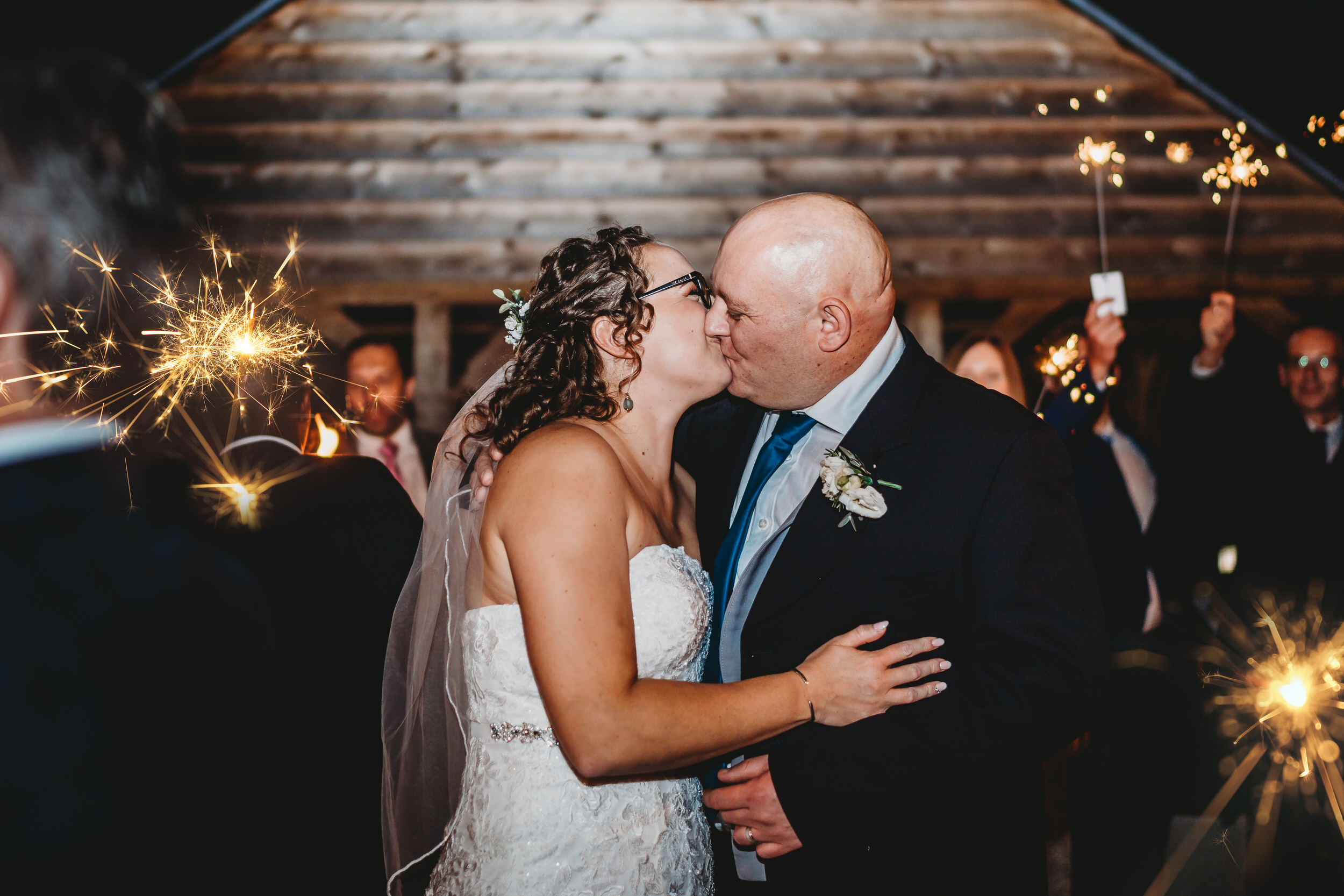a bride and groom kissing in the middle of sparkler line up