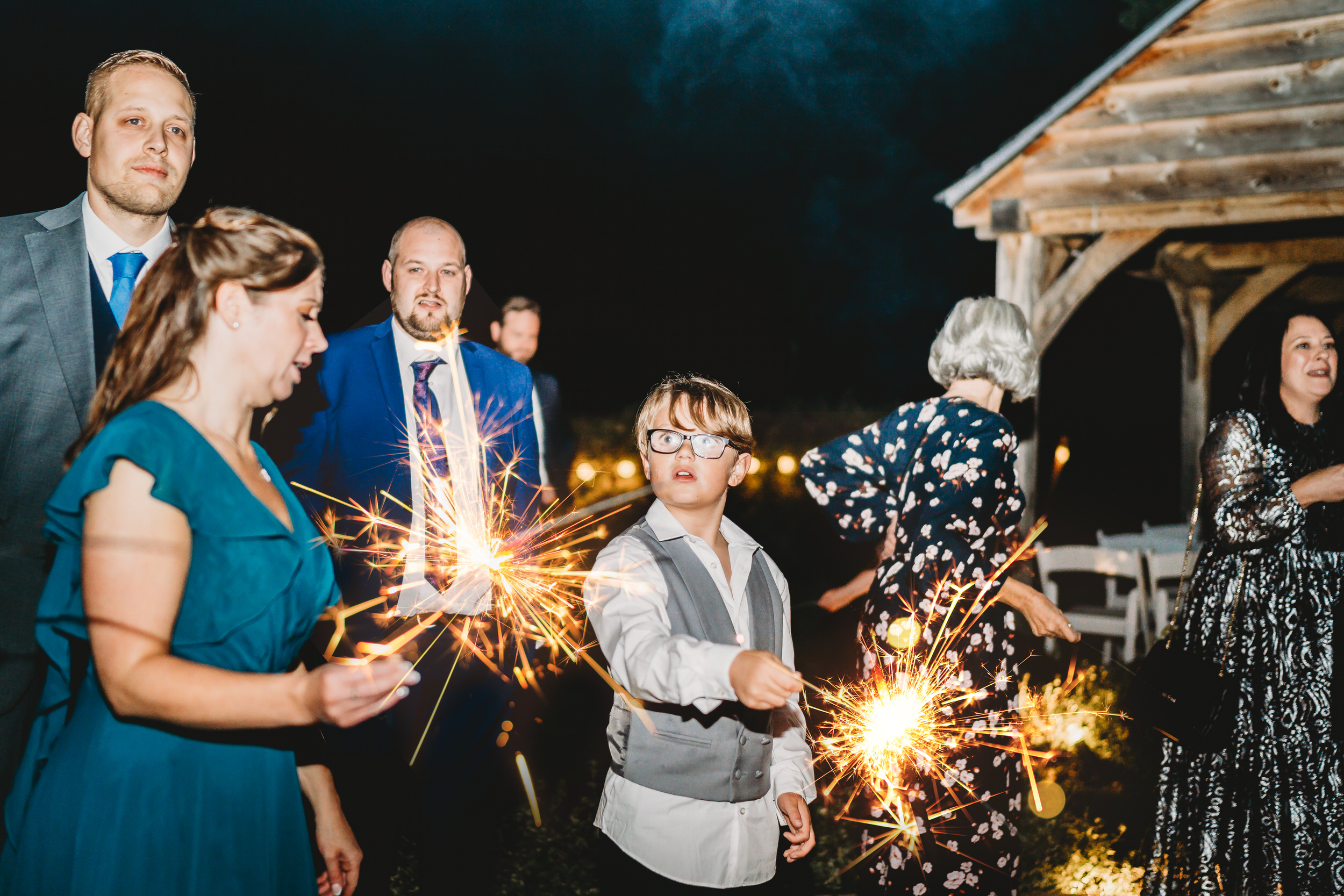 a page boy playing with a sparkler during a wedding for a hampshire wedding photographer