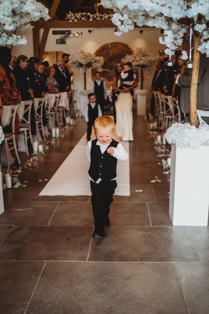 a page boy marching down the aisle at the post barn newbury