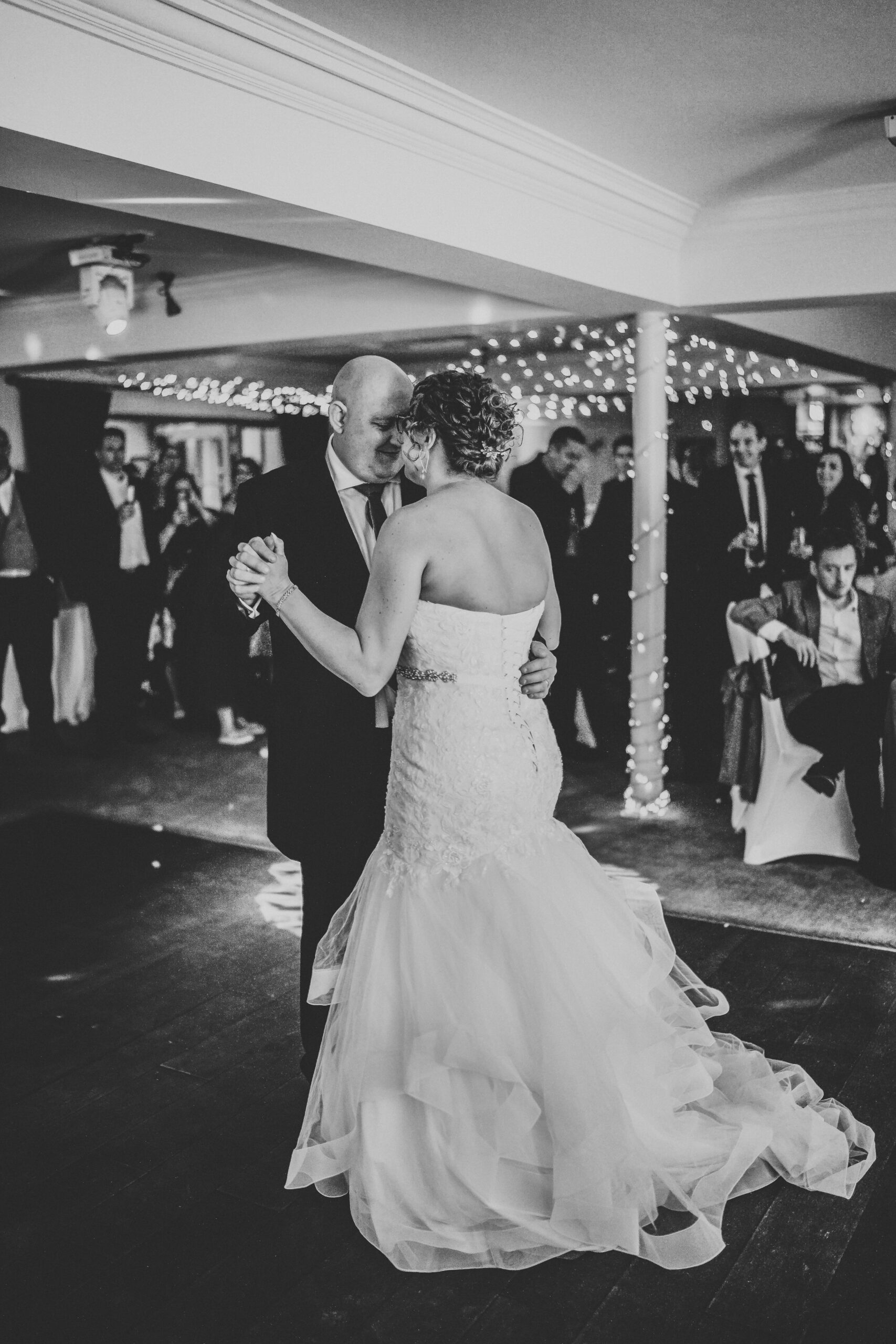 a black and white photograph of a bride and groom having their first dance taken by a wedding photographer in hampshire 