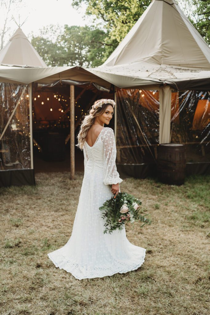 a bridal portrait showing off her beautiful boho dress and bouquet taken by a festival wedding photographer 