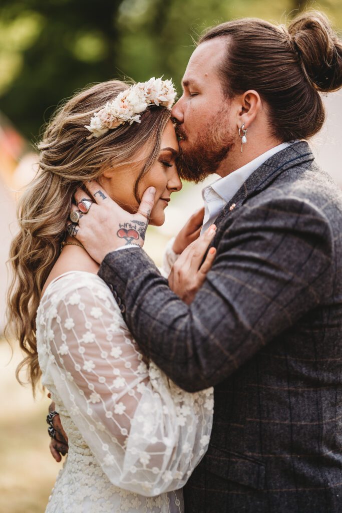 a groom kissing his new wifes forehead 