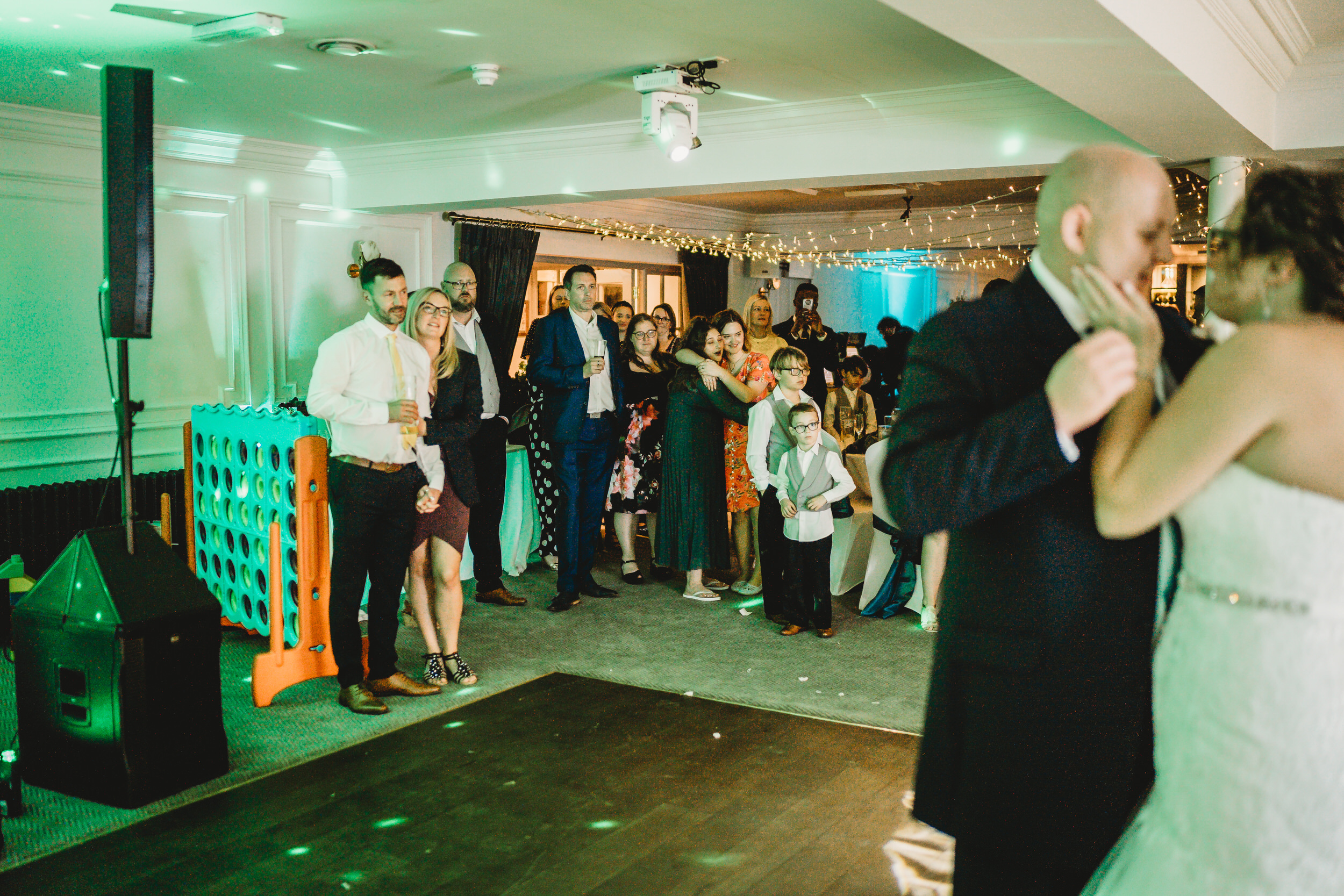 a bride and groom enjoying theit first dance after their wedding whilst the guests look on