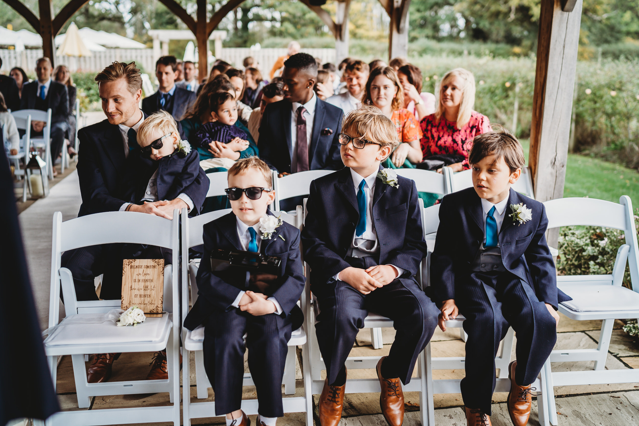 three page boys sat at the front row of their parents wedding ceremony
