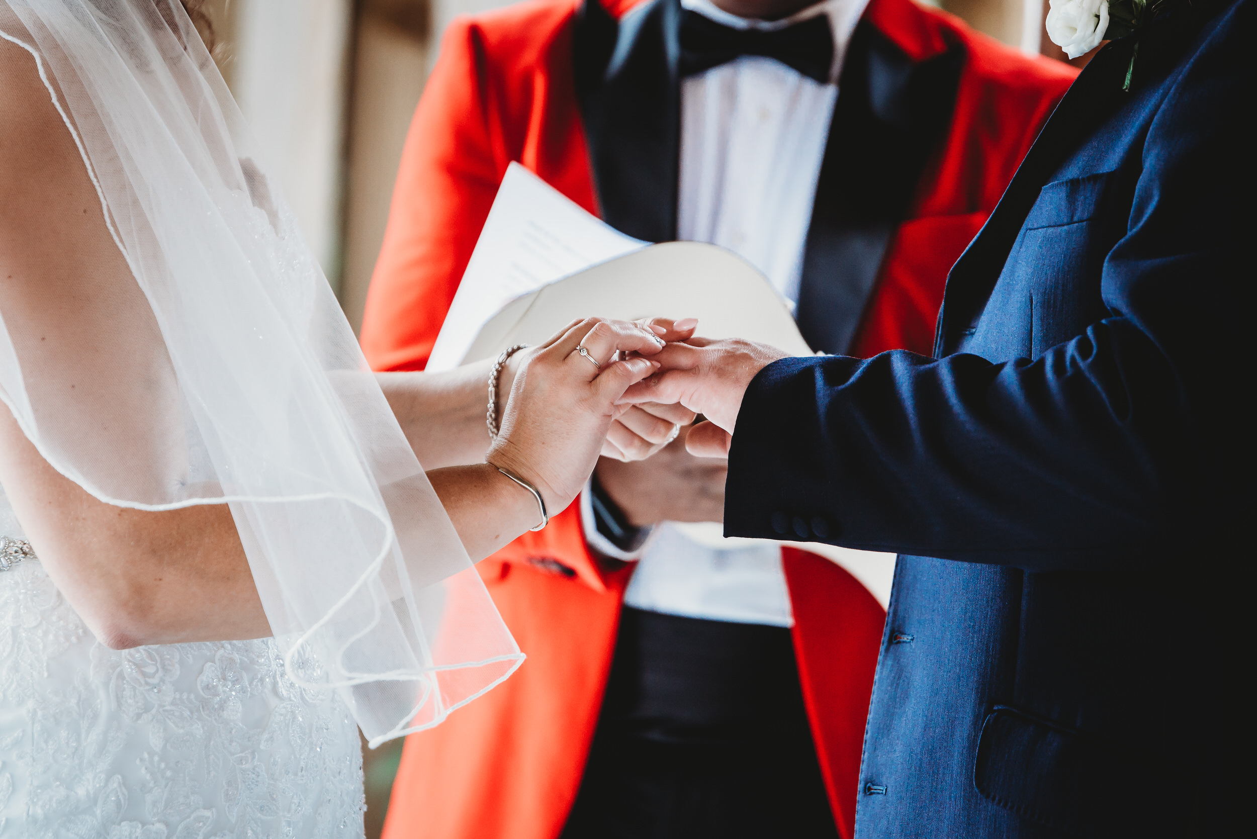 hampshire wedding photography of a bride putting the wedding band on to her husband to bes finger 