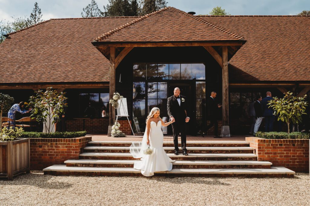 wedding photography of a bride leading a groom down the stairs