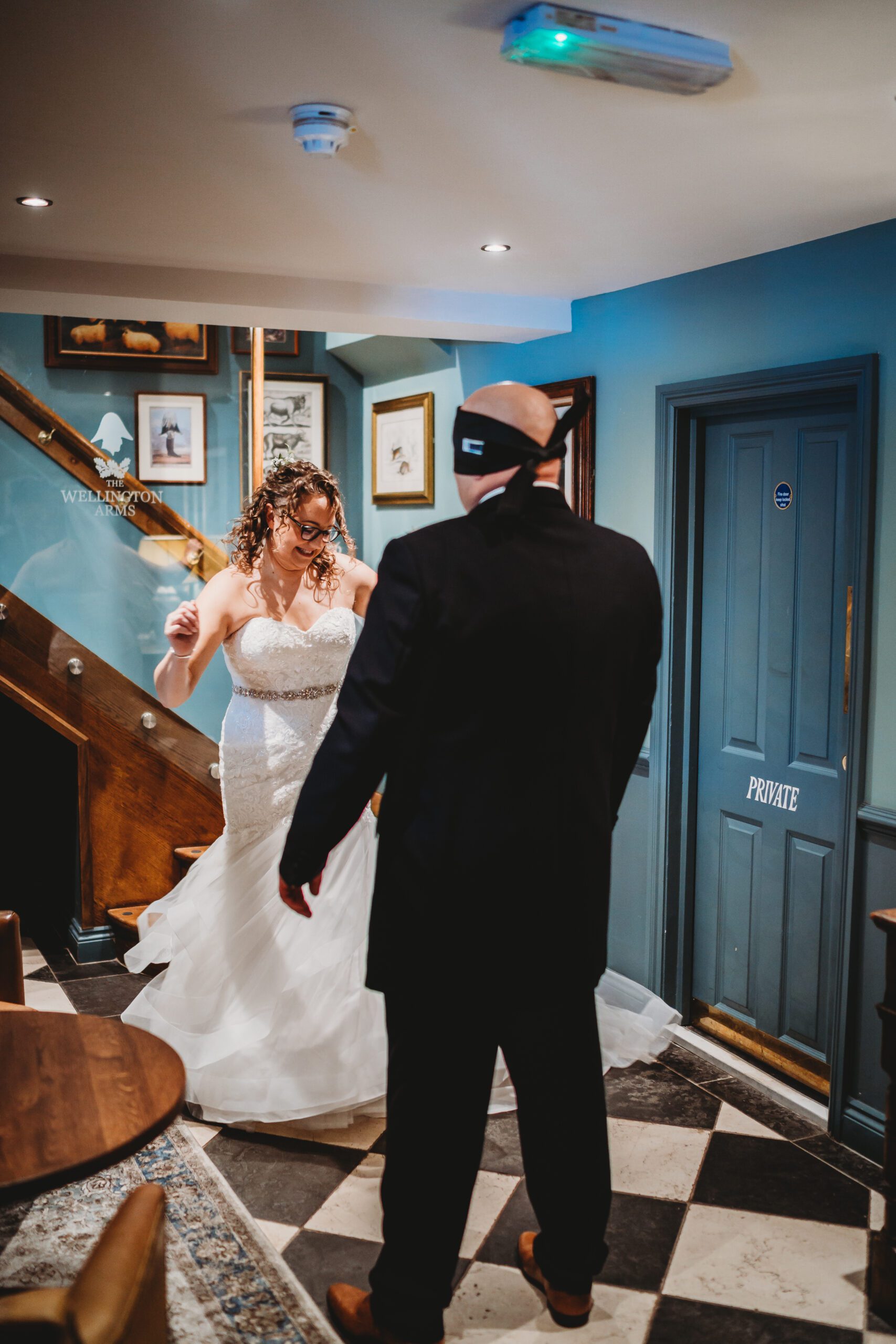 a bride dancing in front of her husband during their blind look before their wedding 