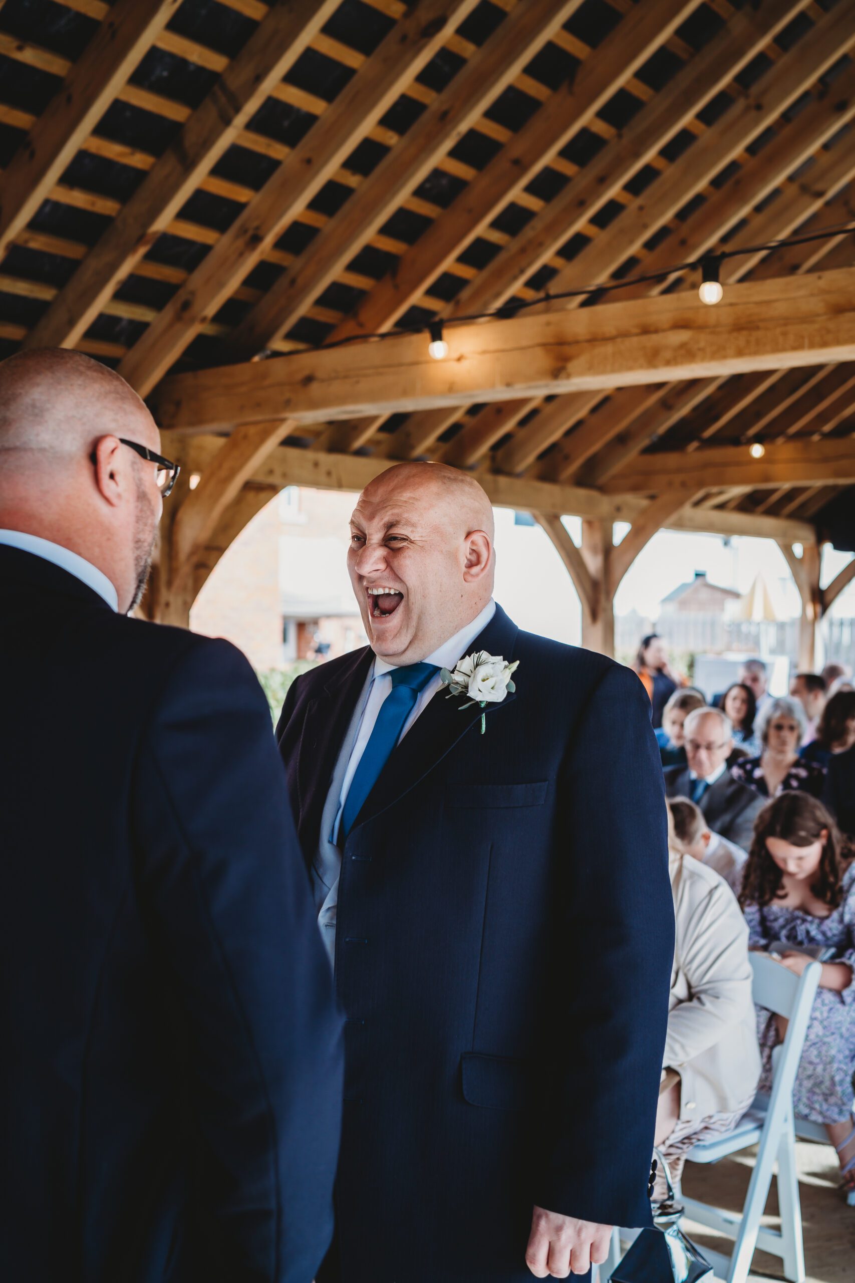 a groom joking with his best man whilst waiting for the bride as taken by a hampshire wedding photographer