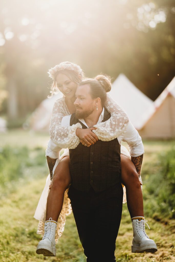 a groom giving his new bride a piggy back ride during for an alternative wedding photographer 