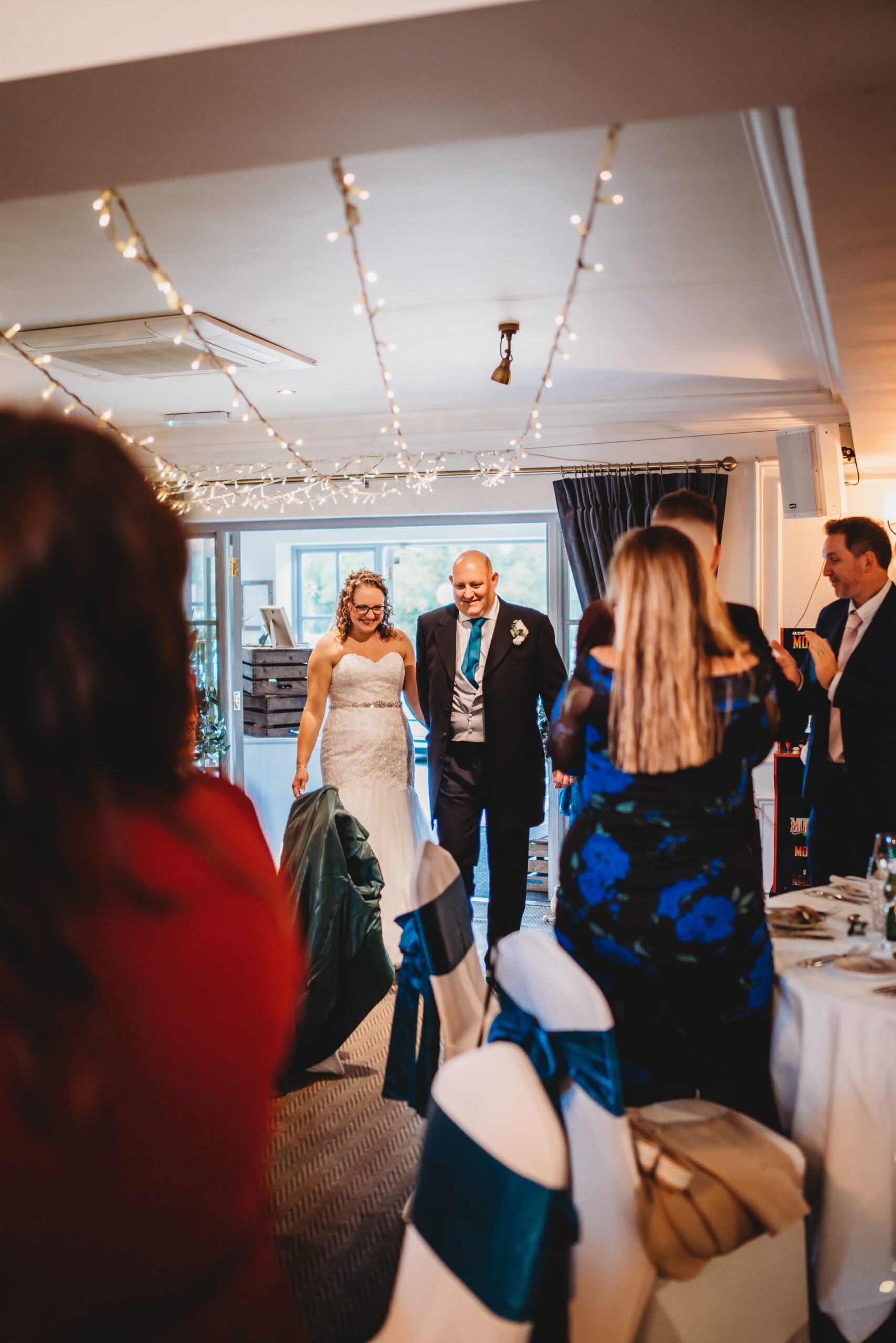 a bride and groom entering their reception room ready for their wedding breakfast taken by a wedding photographer 