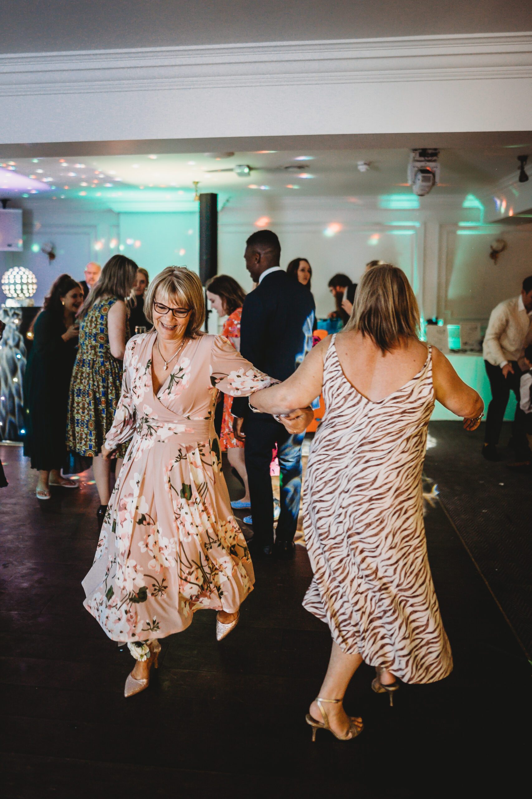 two guests dancing whilst linking arms for a wedding reception 