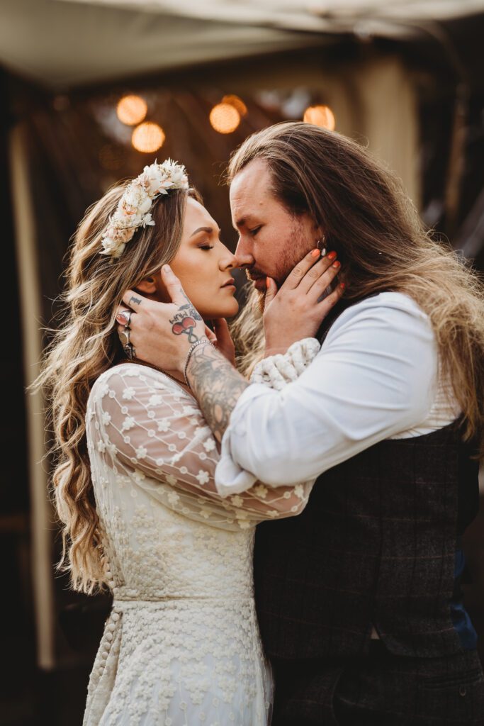 a close up of festival wedding photography of a bride and groom holding each other 