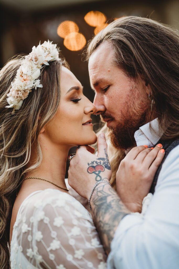 a bride and groom cuddling in together about to kiss