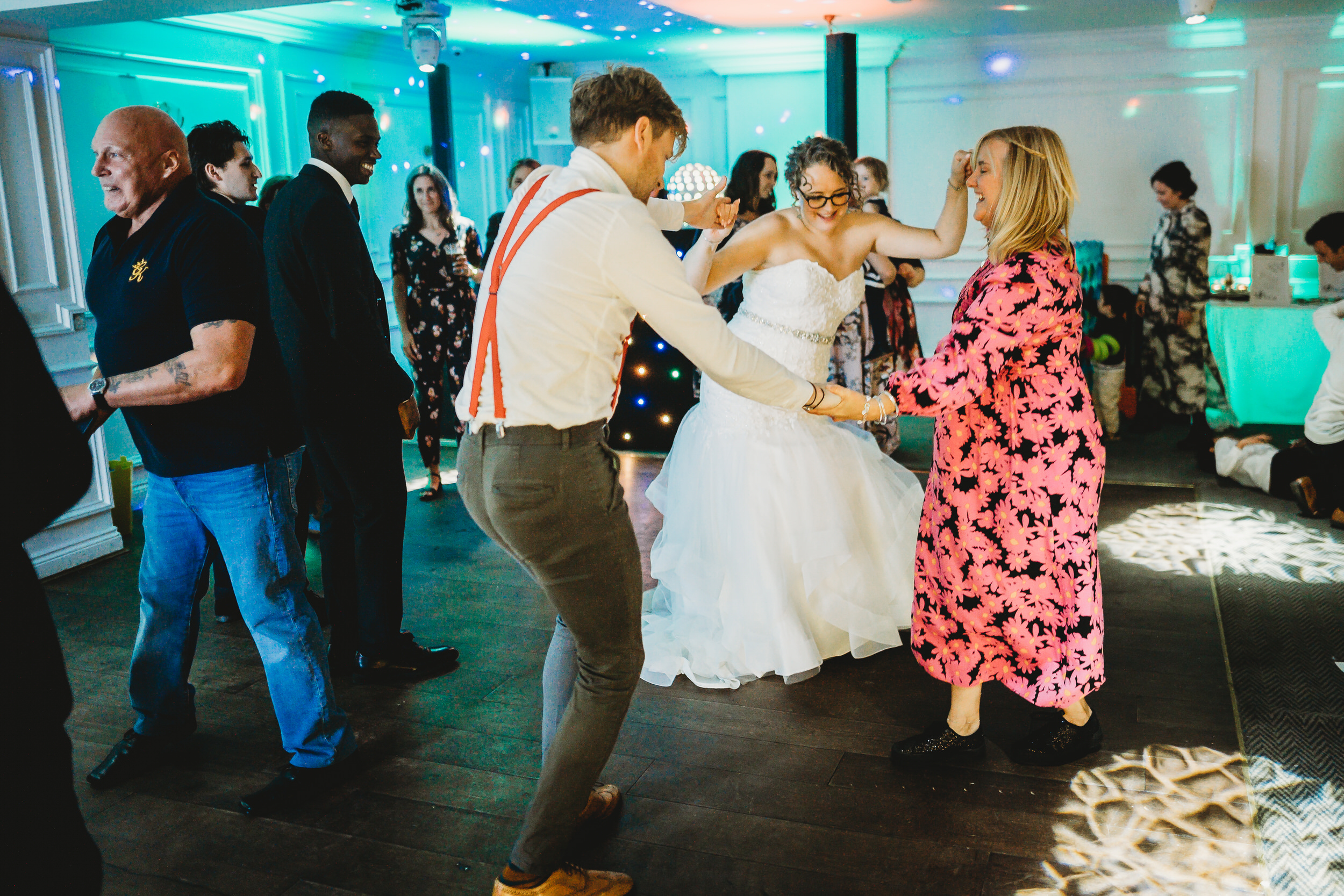 a bride dancing with her brother and sister at her wedding reception