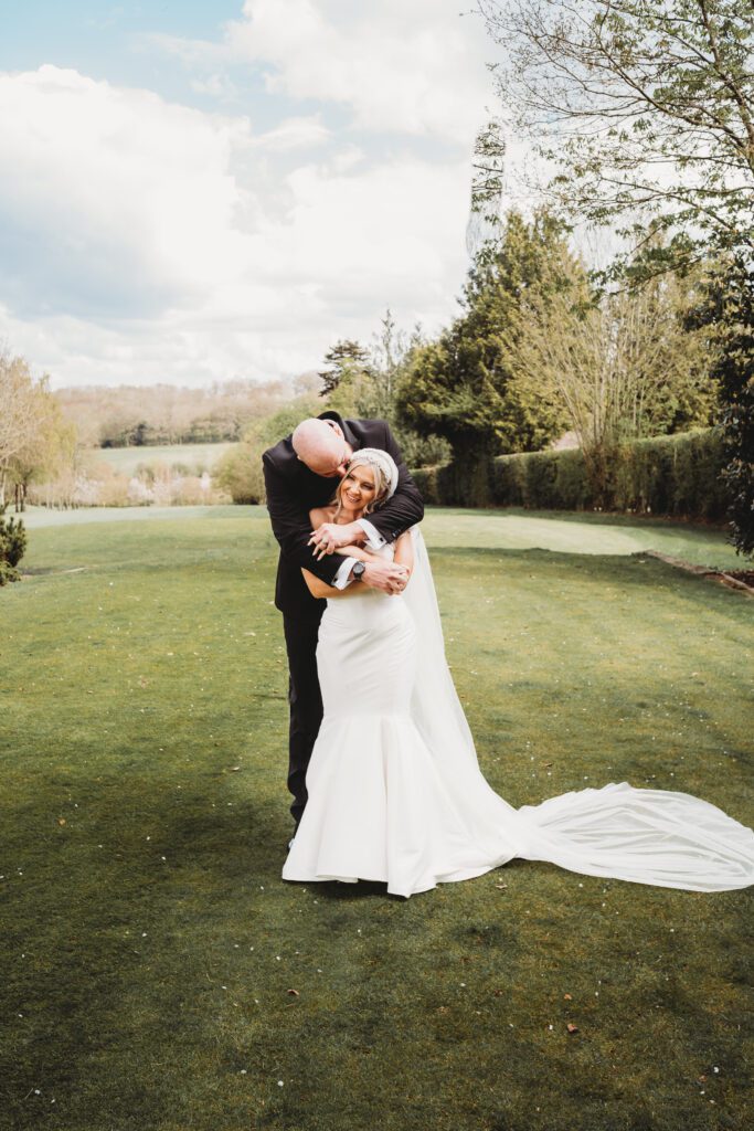 a groom cuddles his bride from behind