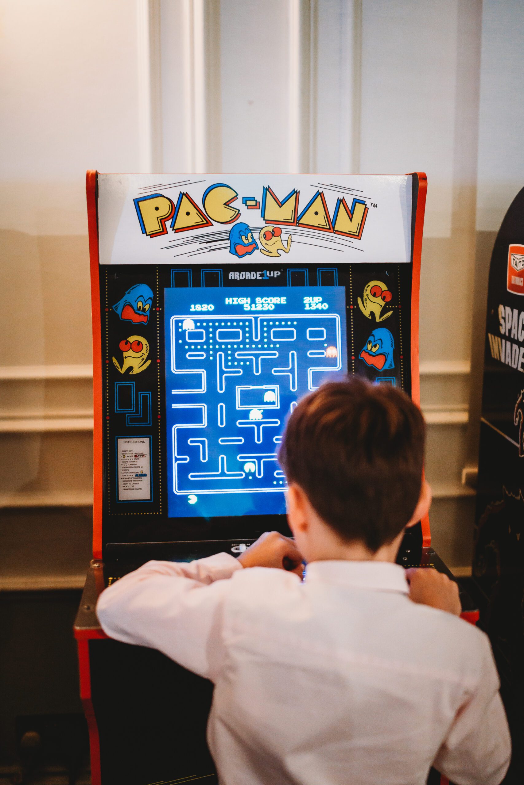 a child playing a retro pac man game at a wedding reception for a hampshire wedding 