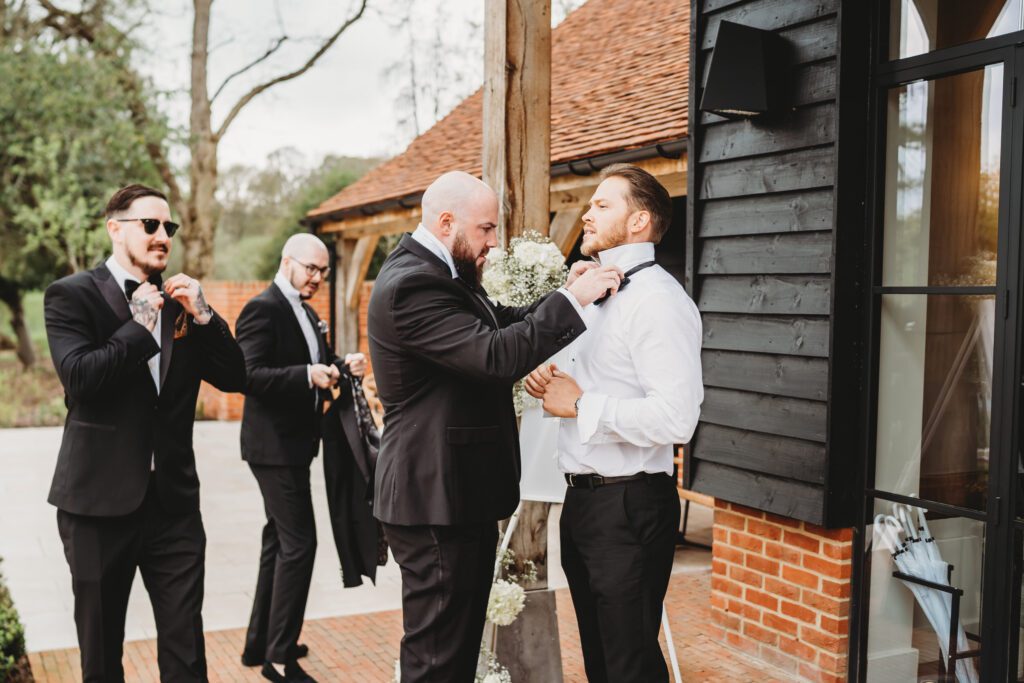 wedding photography of the grooms men getting ready at the post barn newbury