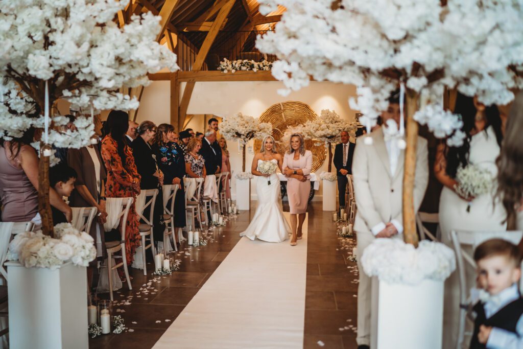 the bride walking down the aisle with her mother taken by a newbury wedding photographer 