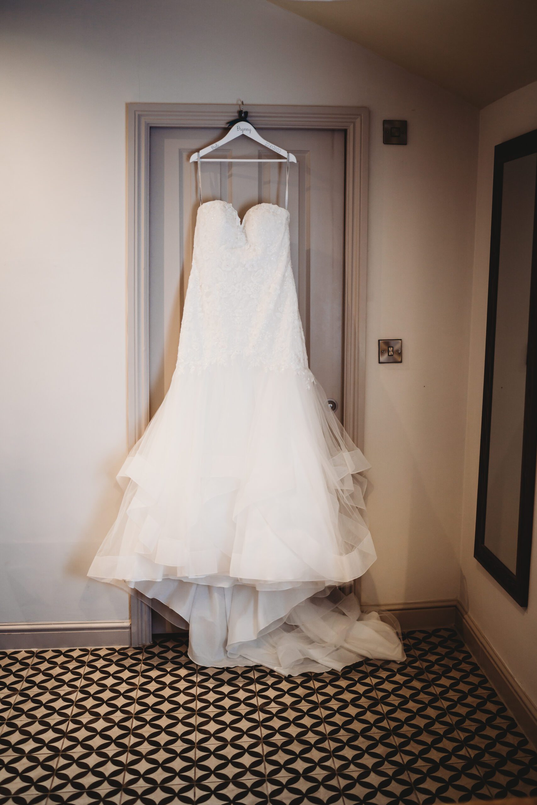 a brides wedding dress hung up for a hampshire wedding photographer to take pictures 