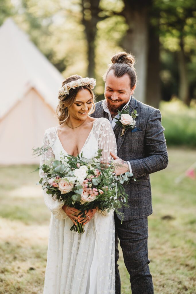 a newly wed couple cuddling together and smiling for a festival wedding photographer 