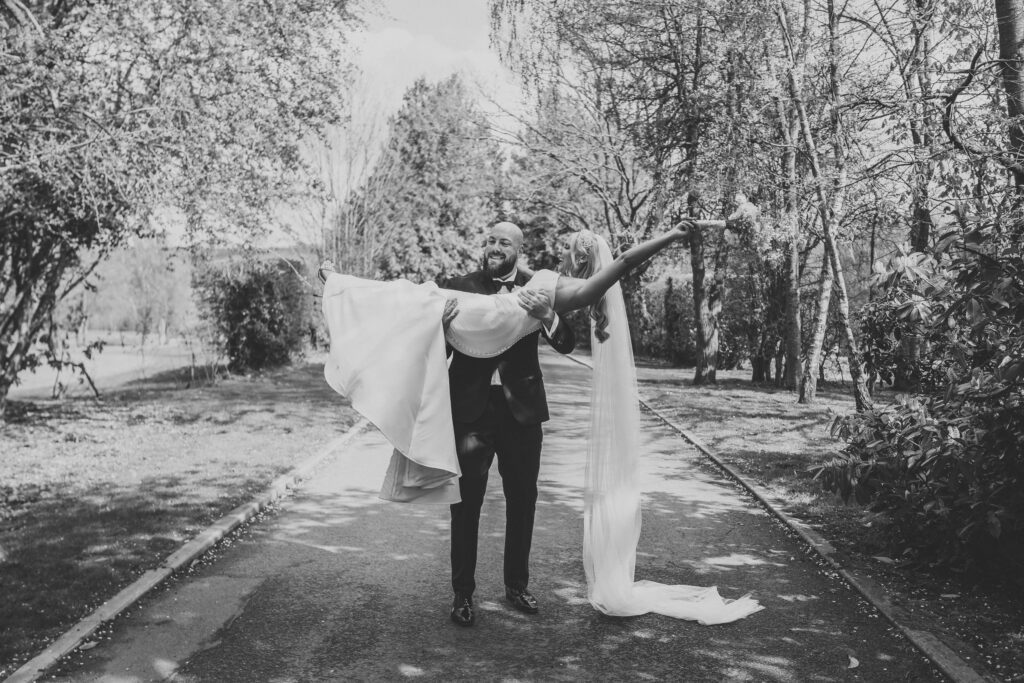 a groom picking up his newly wed wife after their ceremony