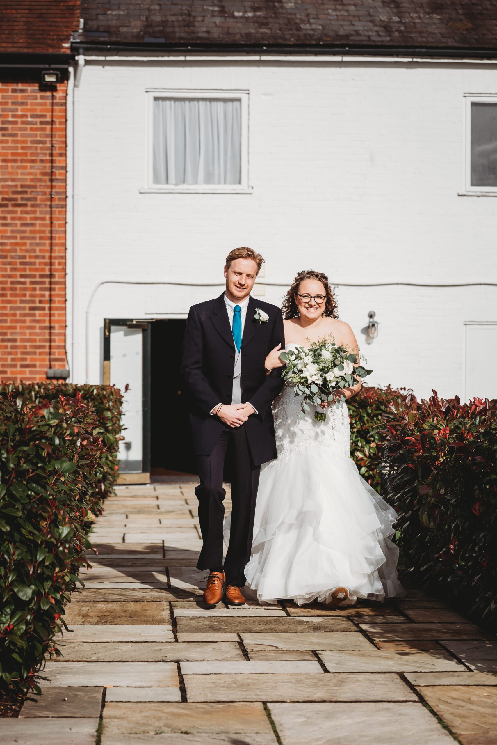 a bride walking down the aisle with her brother as taken by a hampshire wedding photographer 