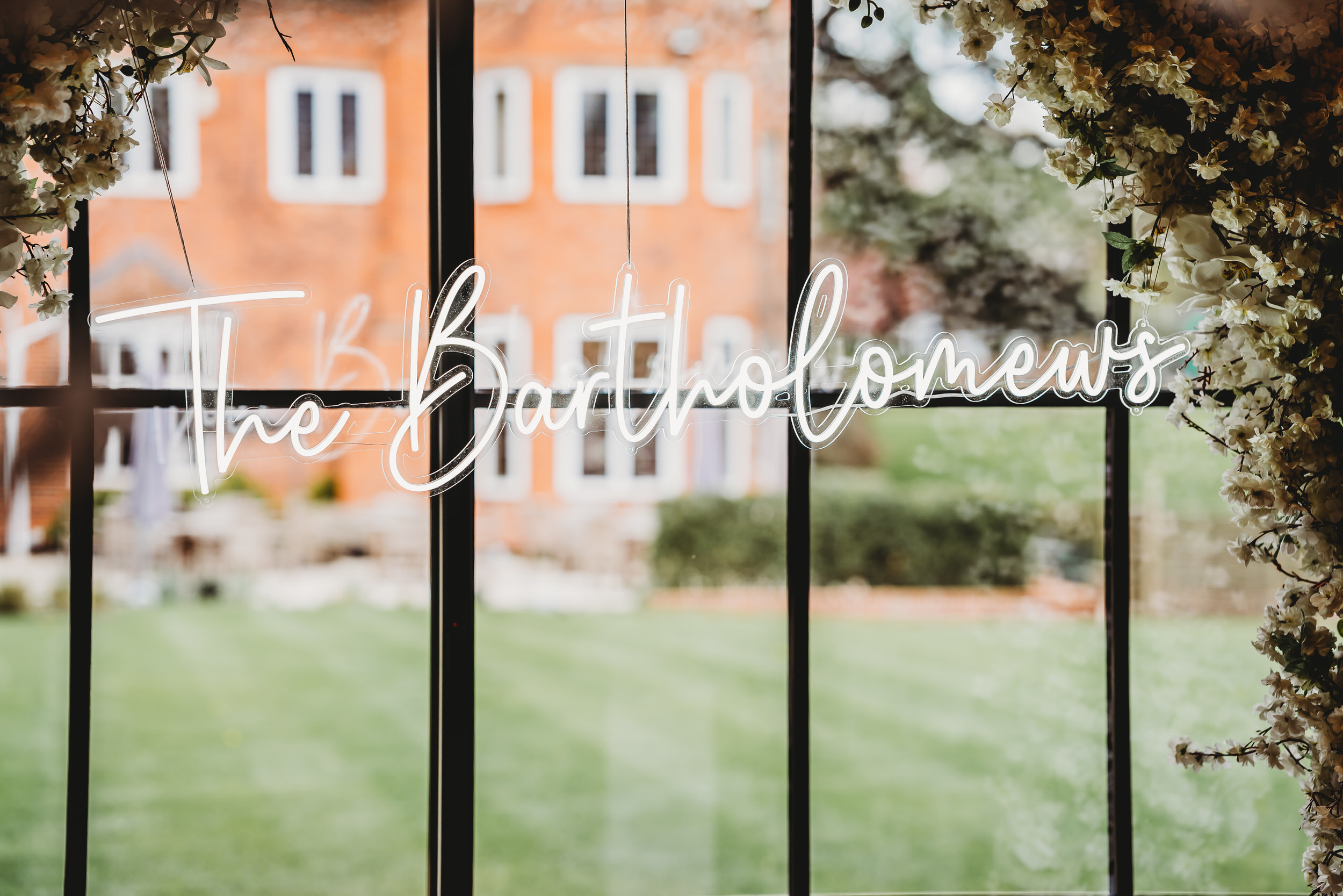 a new-weds white neon sign at the front of their ceremony room 