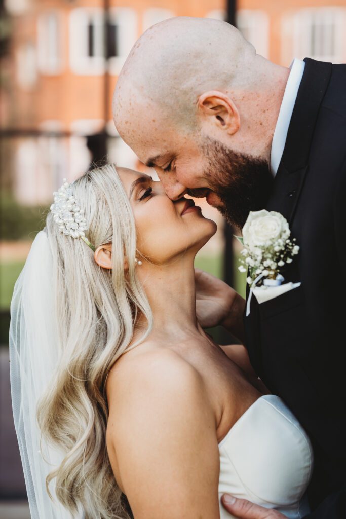 groom leaning in to kiss his bride for a newbury wedding photographer 