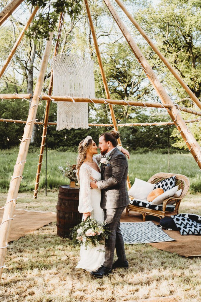 a newly wed couple under a naked tipi at Woolley Park Estate