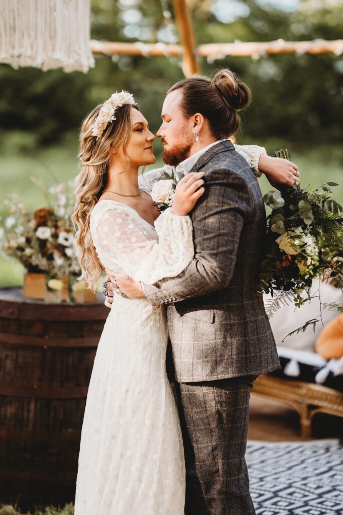 a newly wed husband and wife cuddling up together for a festival wedding photographer 